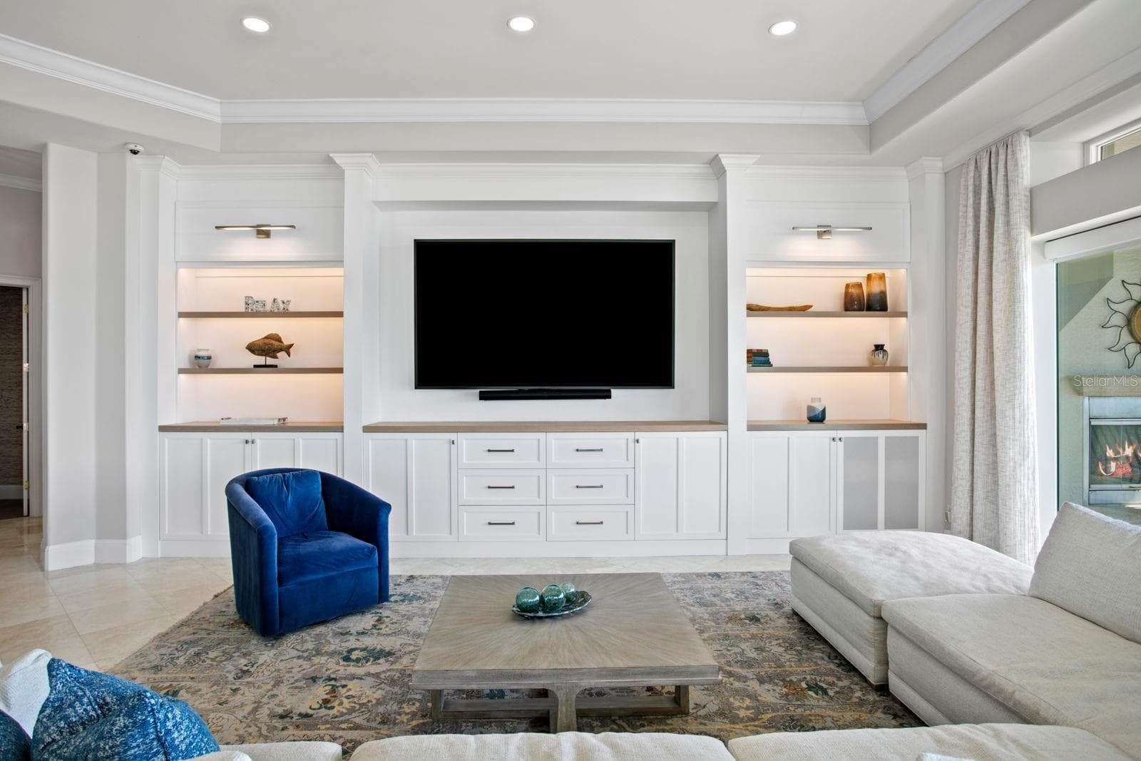 The family room features a beautifully designed entertainment wall with custom built-in cabinetry and integrated media space. - 611 1ST AVE S, TIERRA VERDE