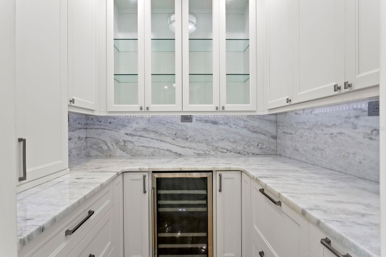 A sophisticated butler's pantry located just off the kitchen offers an expansive prep area for entertaining and includes a wine refrigerator. - 611 1ST AVE S, TIERRA VERDE