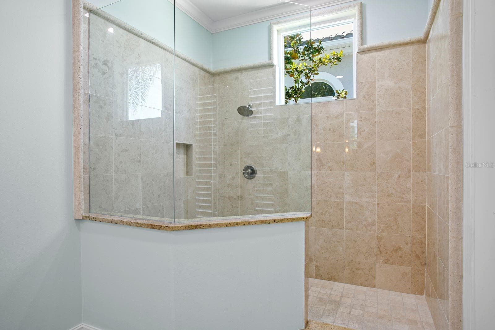 View of the walk-in shower in the main level primary ensuite. - 611 1ST AVE S, TIERRA VERDE