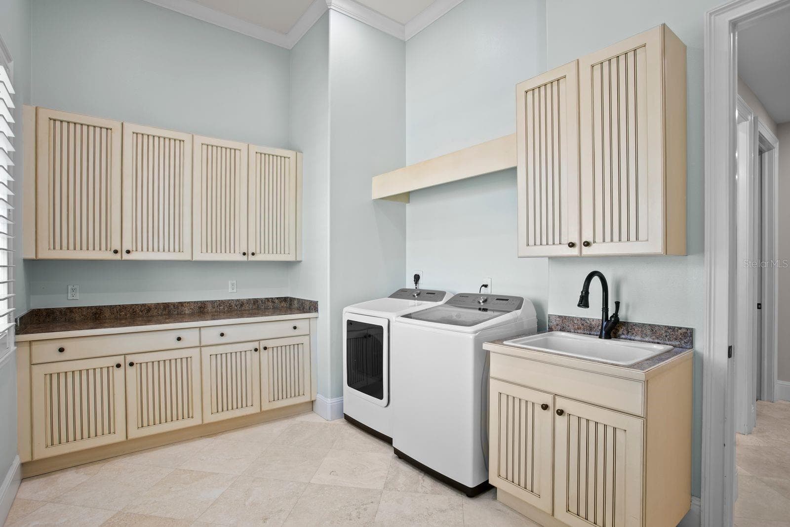 Spacious laundry with linen closets and a dedicated workspace. - 611 1ST AVE S, TIERRA VERDE