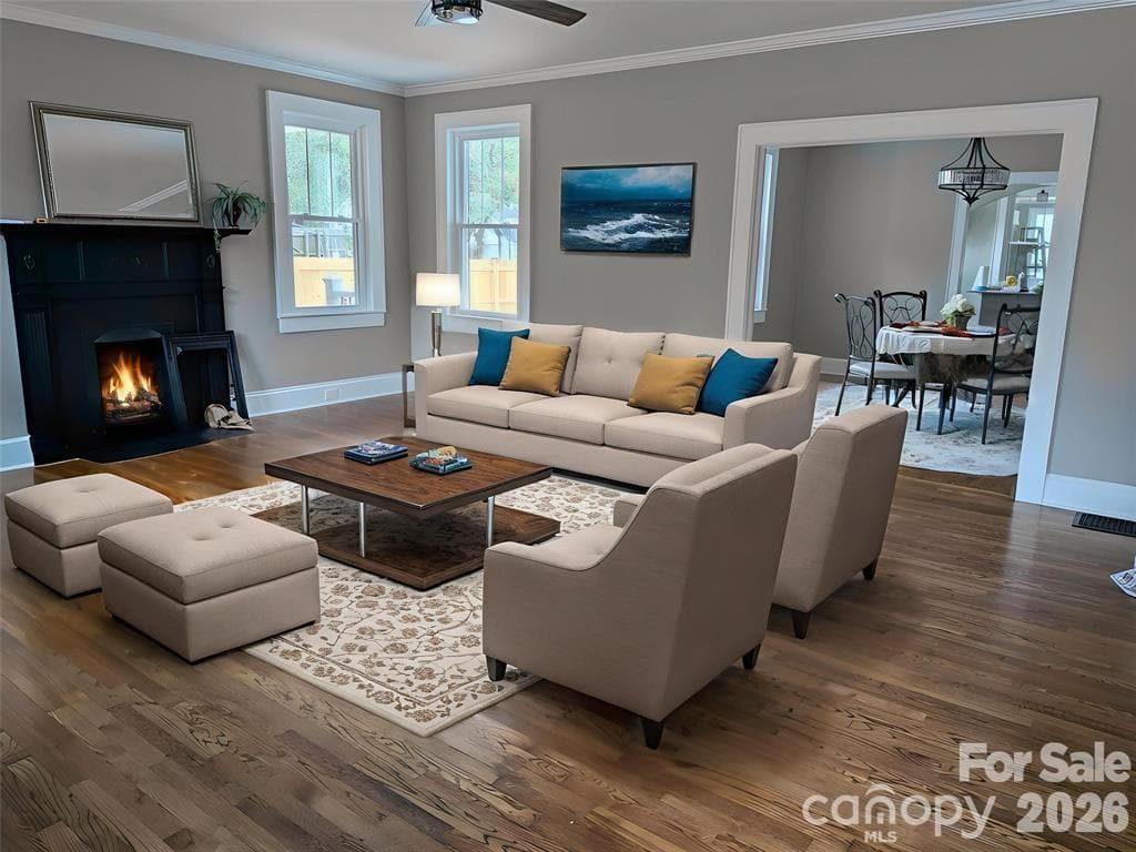 Virtually staged Living room w/fireplace,gleaming wood floors, 9 ft ceilings, crown molding & Argan energy efficient windows t/o. Fireplace has electric logs, but is ready for gas logs if you wish. - 933 W Warren Street, Shelby