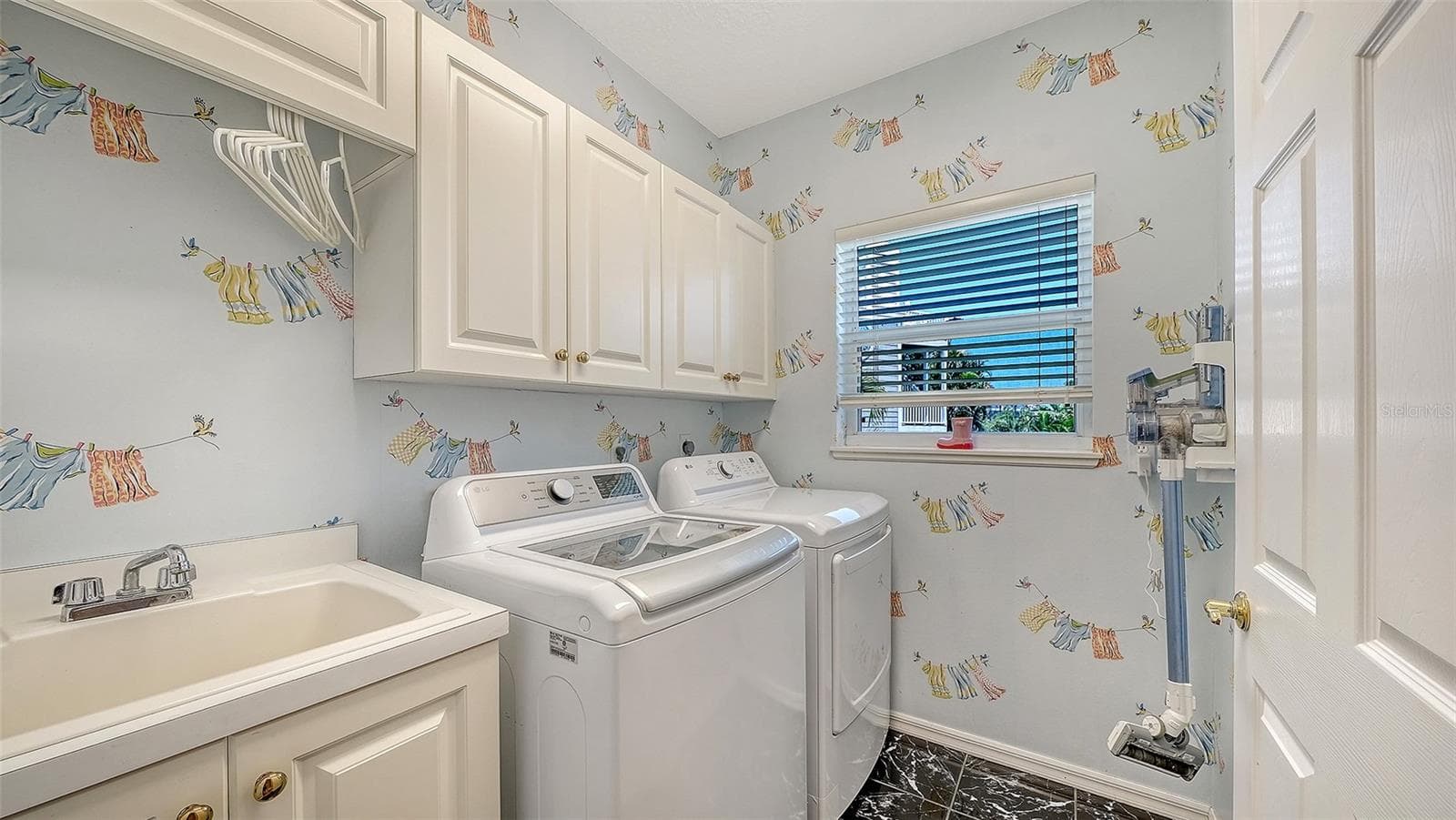 Thoughtfully designed split-level floor plan Second and a half level laundry room features full sized washer and new 2026 dryer, built in laundry sink and storage cabinetry with tile floors. - 3040 GULF OF MEXICO DR #3, LONGBOAT KEY