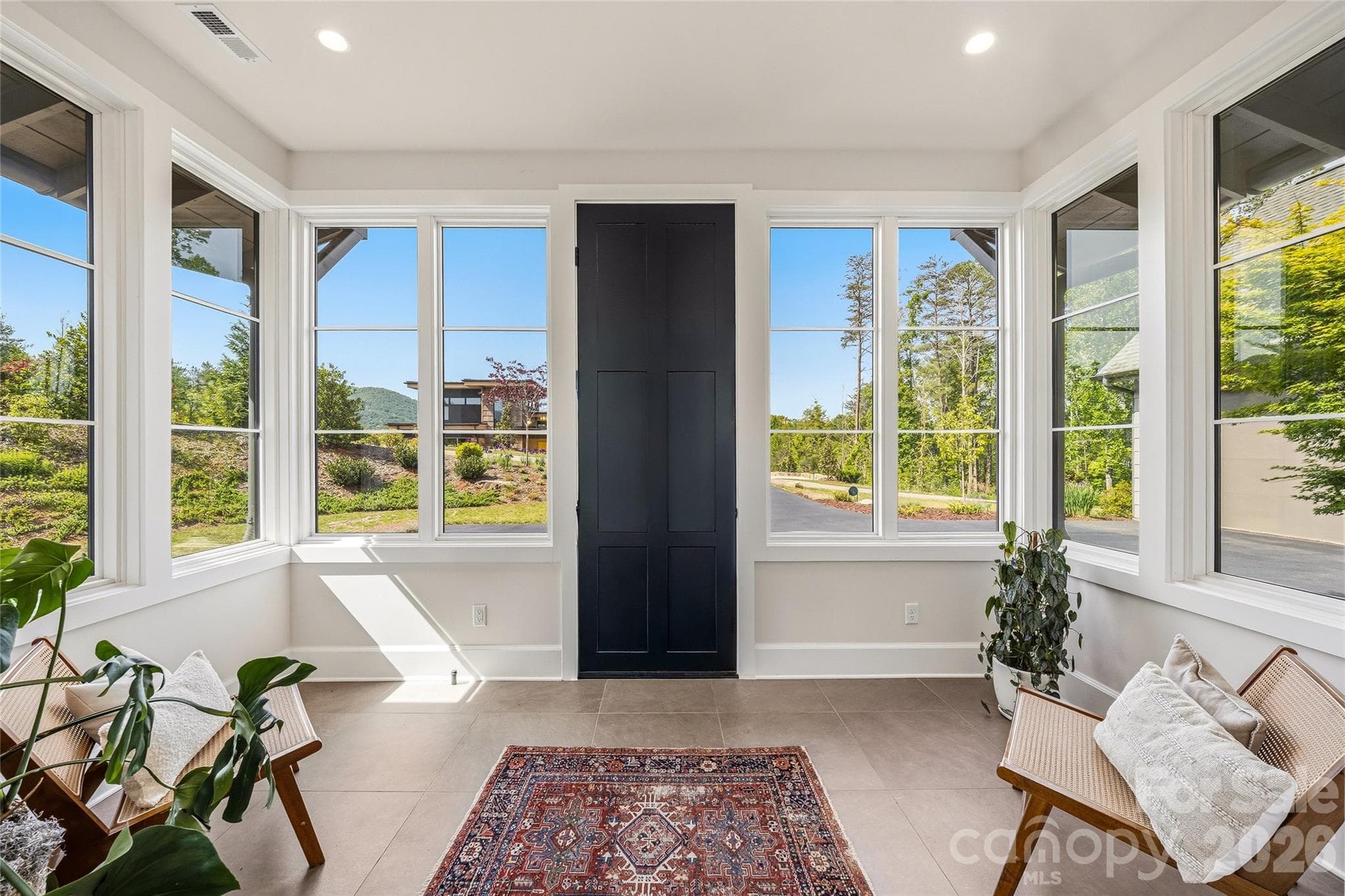 The sunny foyer/sunroom brings the outside in - 162 Riverbend Forest Drive, Asheville