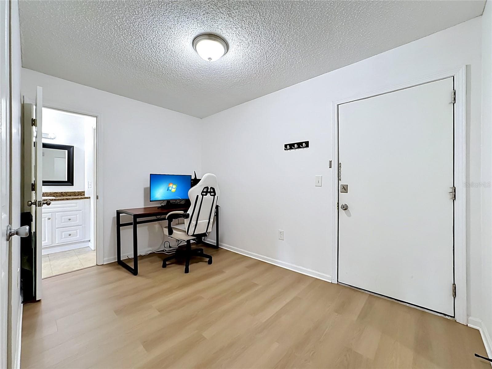Front door opens up into a multi purpose space currently being used as a home office. - 5507 FOUNTAIN LAKE CIR #B206, BRADENTON