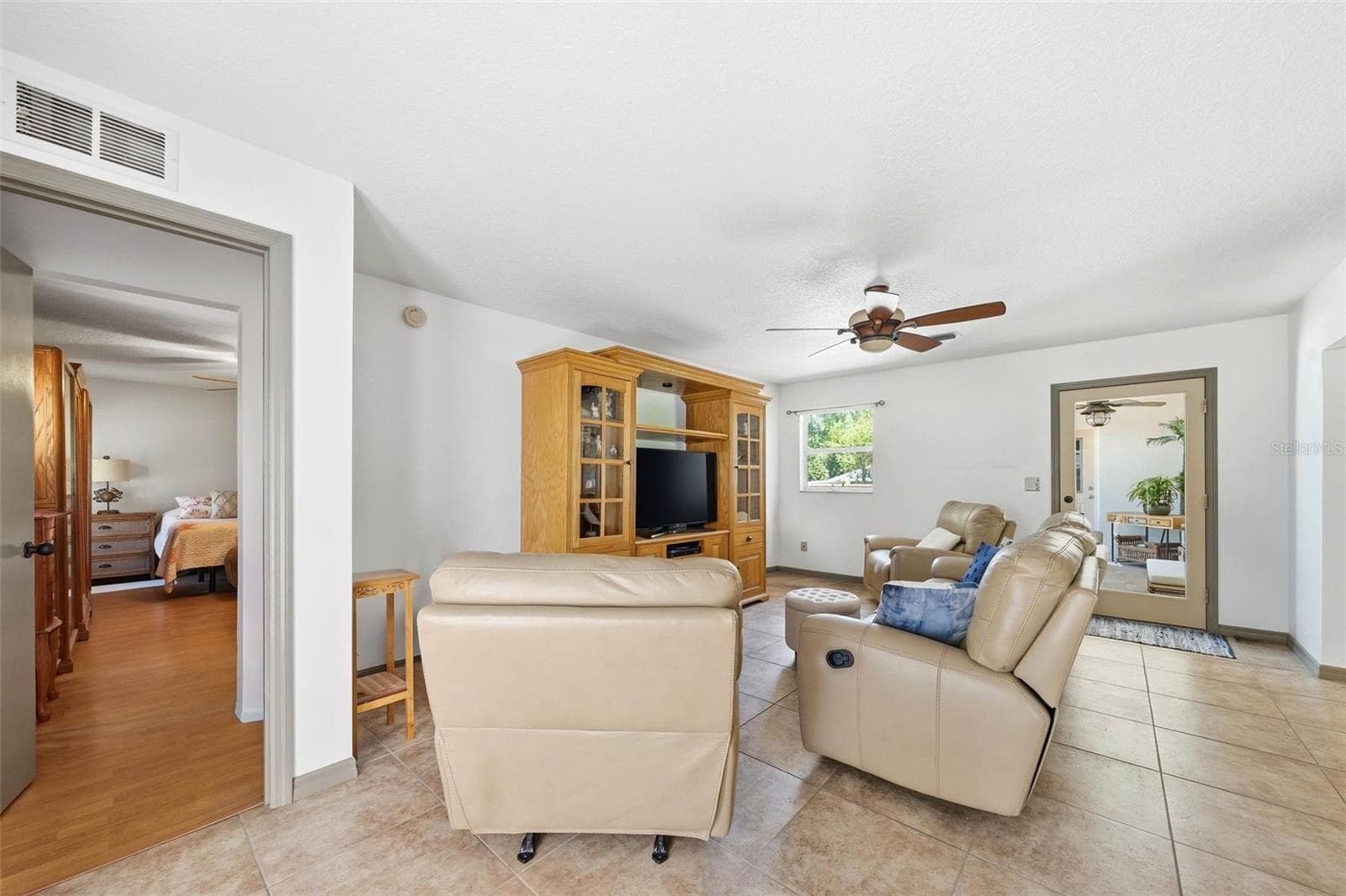 family room with Master bedroom entry on the left and glass door to the screened porch - 37237 GRAYS AIRPORT RD, LADY LAKE