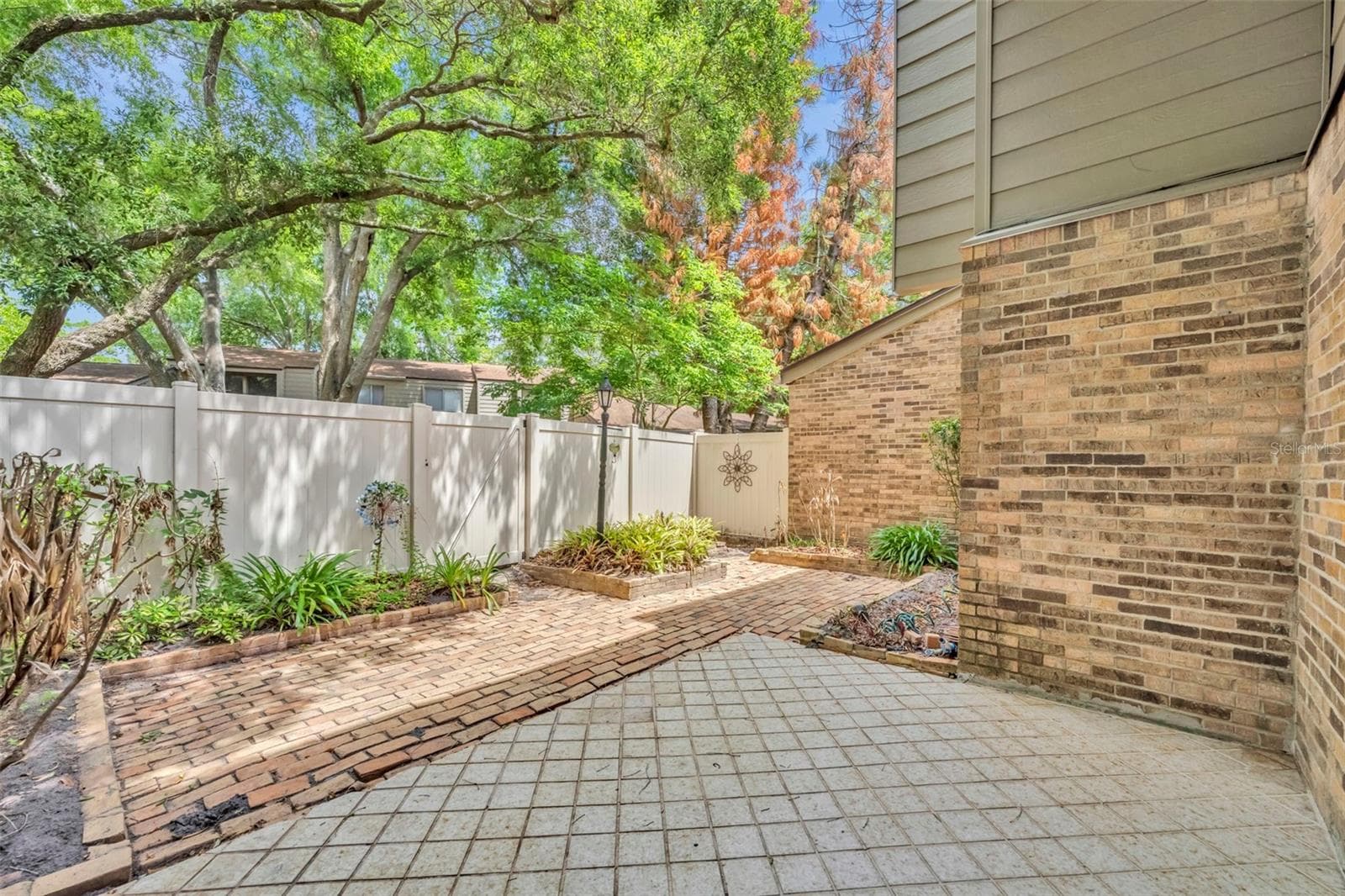 Private brick patio with fence opening to green space - 497 OAK HAVEN DR #497, ALTAMONTE SPRINGS