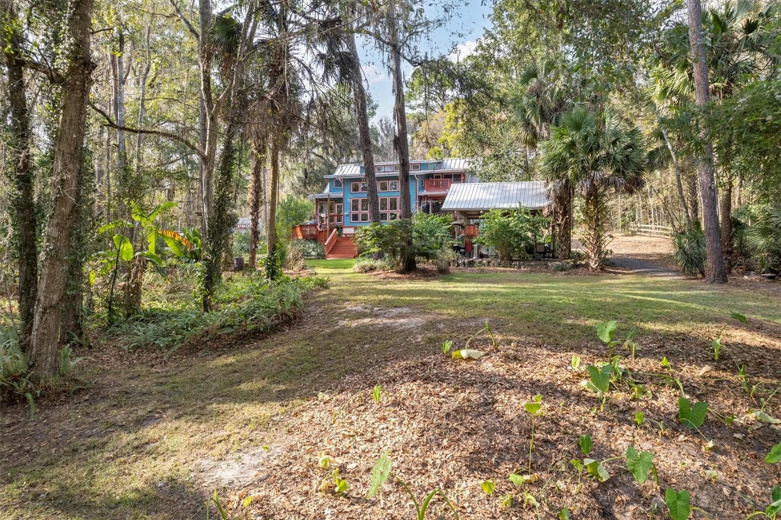 Back of property, view of home and cabana - 22675 NW 75TH AVENUE RD, MICANOPY