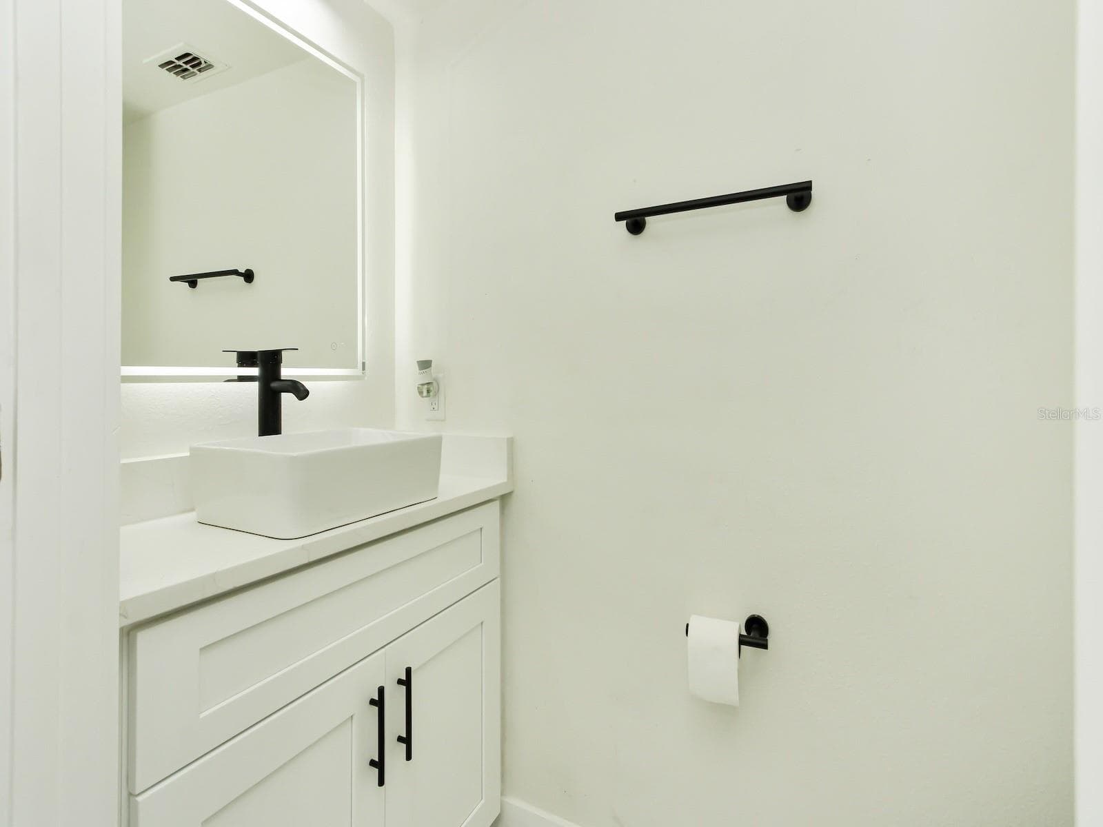 Half bathroom completely renovated with Quartz countertops, sink, light fixtures, toilet, and water features. - 7561 LAKE ANDREA CIR, MOUNT DORA