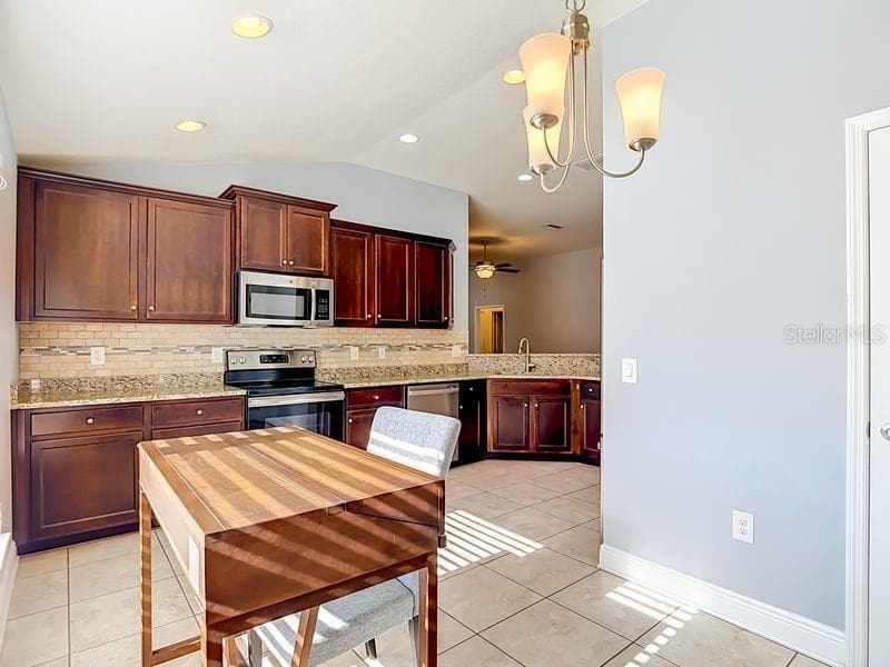 Cozy breakfast nook just off the kitchen, featuring tile floor and warm natural light. Perfect for casual dining, this space sits beside the pantry and offers a comfortable spot to enjoy morning coffee or family meals - 12244 LOOPBACK DR, SAN ANTONIO