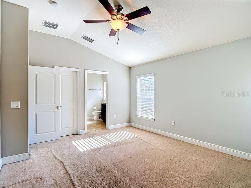 Spacious primary suite featuring vaulted ceilings, soft natural light, and neutral tones that create a relaxing retreat - 12244 LOOPBACK DR, SAN ANTONIO