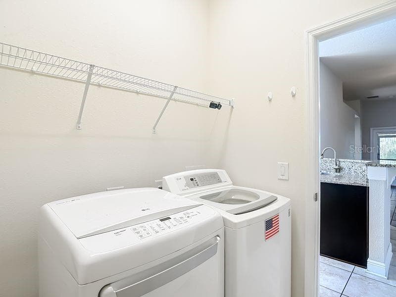 Convenient laundry room located just off kitchen- this space also offers easy access to garage for added functionality - 12244 LOOPBACK DR, SAN ANTONIO