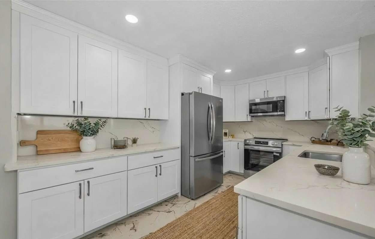 Kitchen with some virtual staging - 100 BLUFF VIEW DR #604C, BELLEAIR BLUFFS