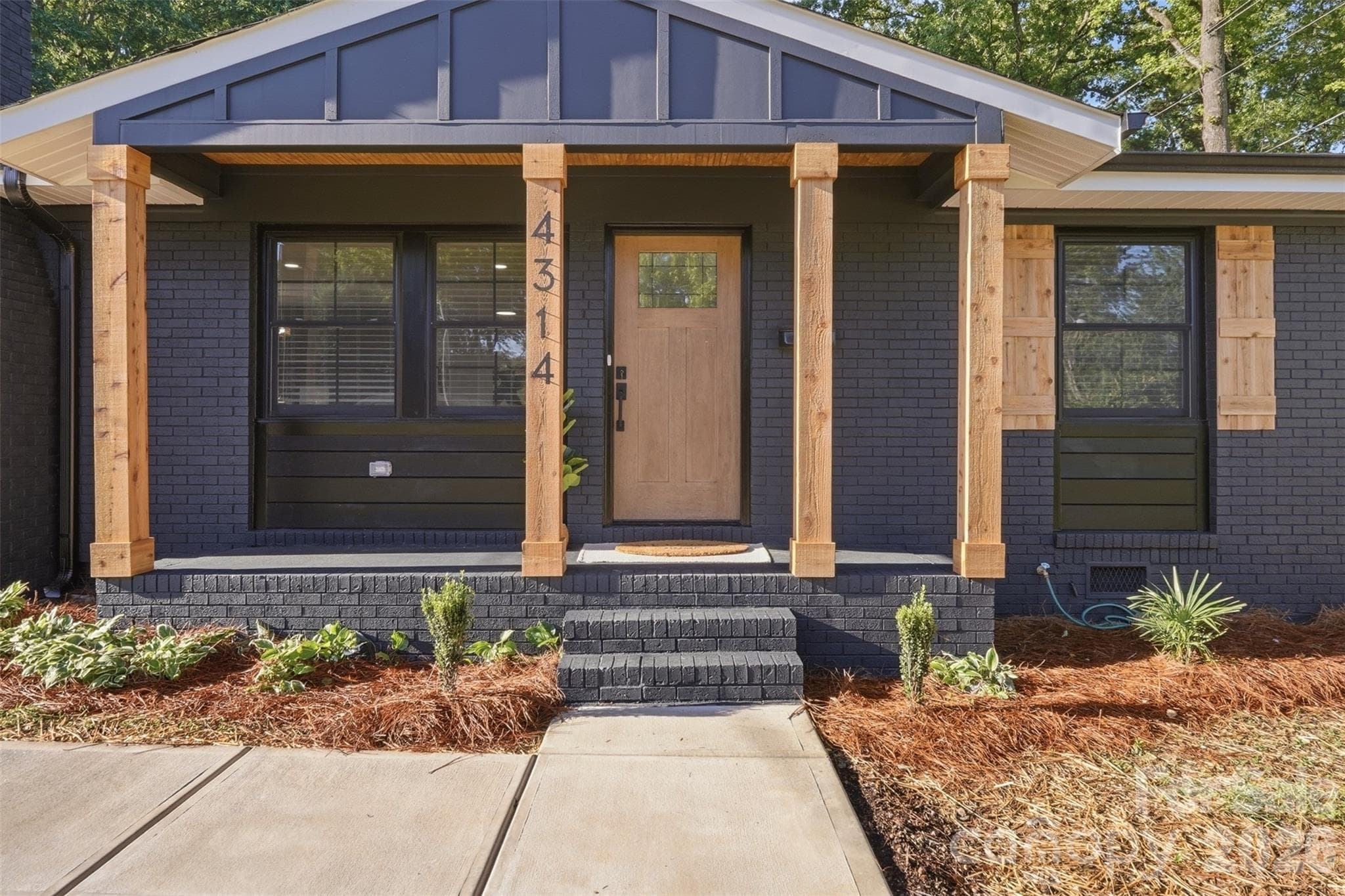 Solid beams match shutters and batten board siding adorns porch ceiling. - Charlotte