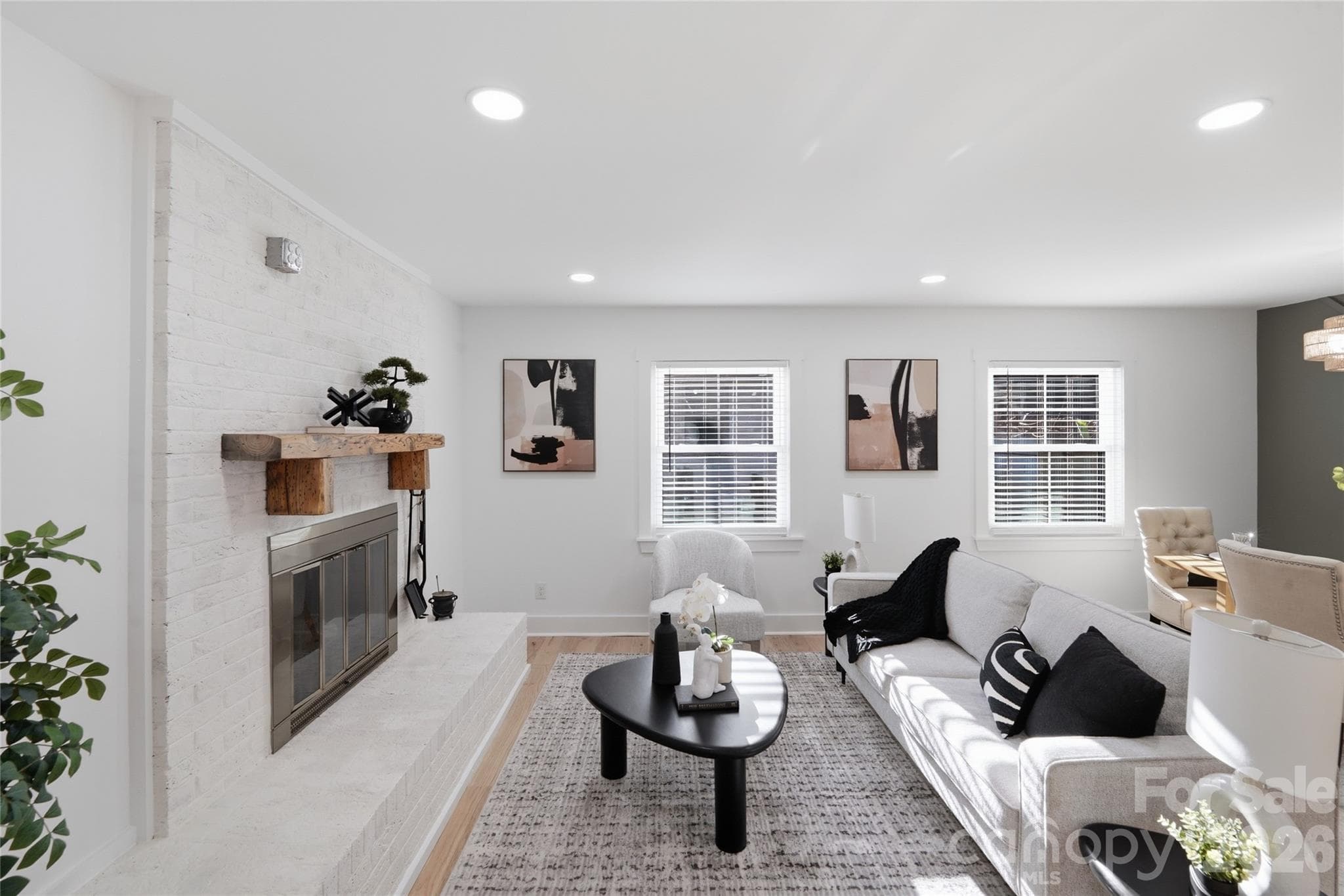 The lime washed, brick fireplace has been updated to incorporate the rustic wood colored mantle. - 4314 Ivanhoe Place, Charlotte