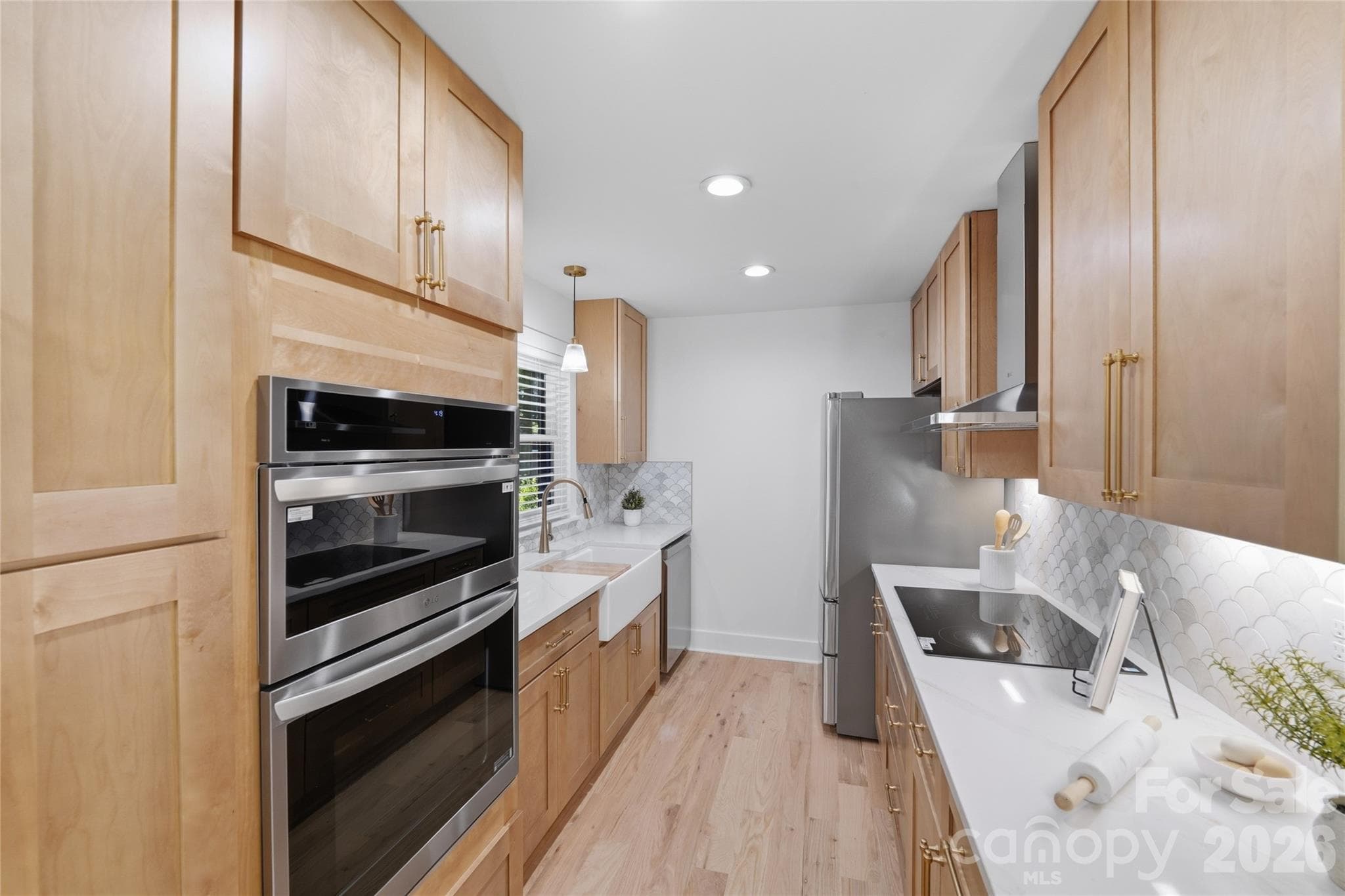 The stunning galley kitchen has been meticulously re done with modern cabinets, quartz counters, coordinating tile backsplash, stainless steel exhaust hood and apron sink. - 4314 Ivanhoe Place, Charlotte