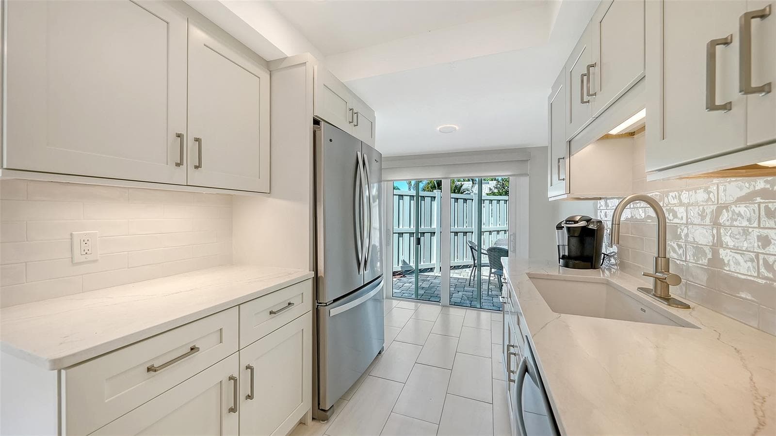 Floor to ceiling sliders open from the kitchen into the patio, for ease of entertaining and grilling. - 206 HOURGLASS WAY #V10, SARASOTA