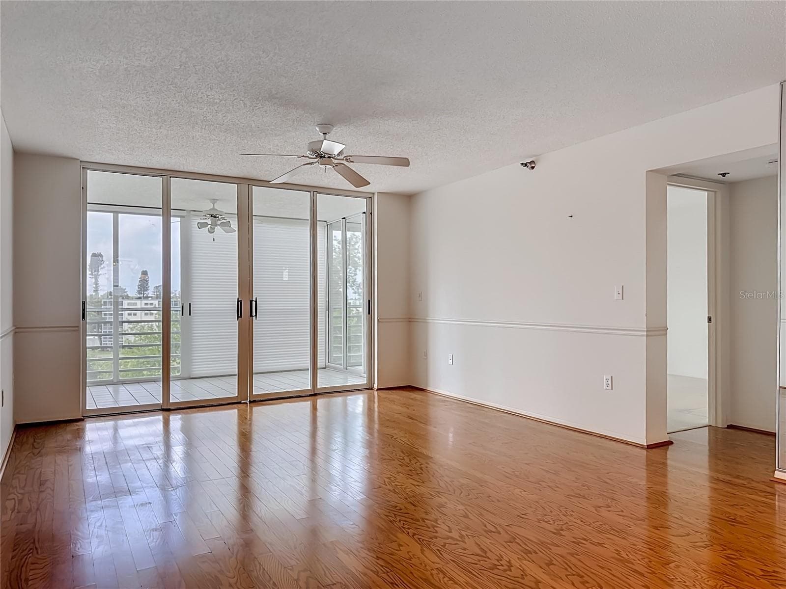 Living room with sliding door to the larger glass enclosed lanai/Florida room. - 3740 PINEBROOK CIR #607, BRADENTON