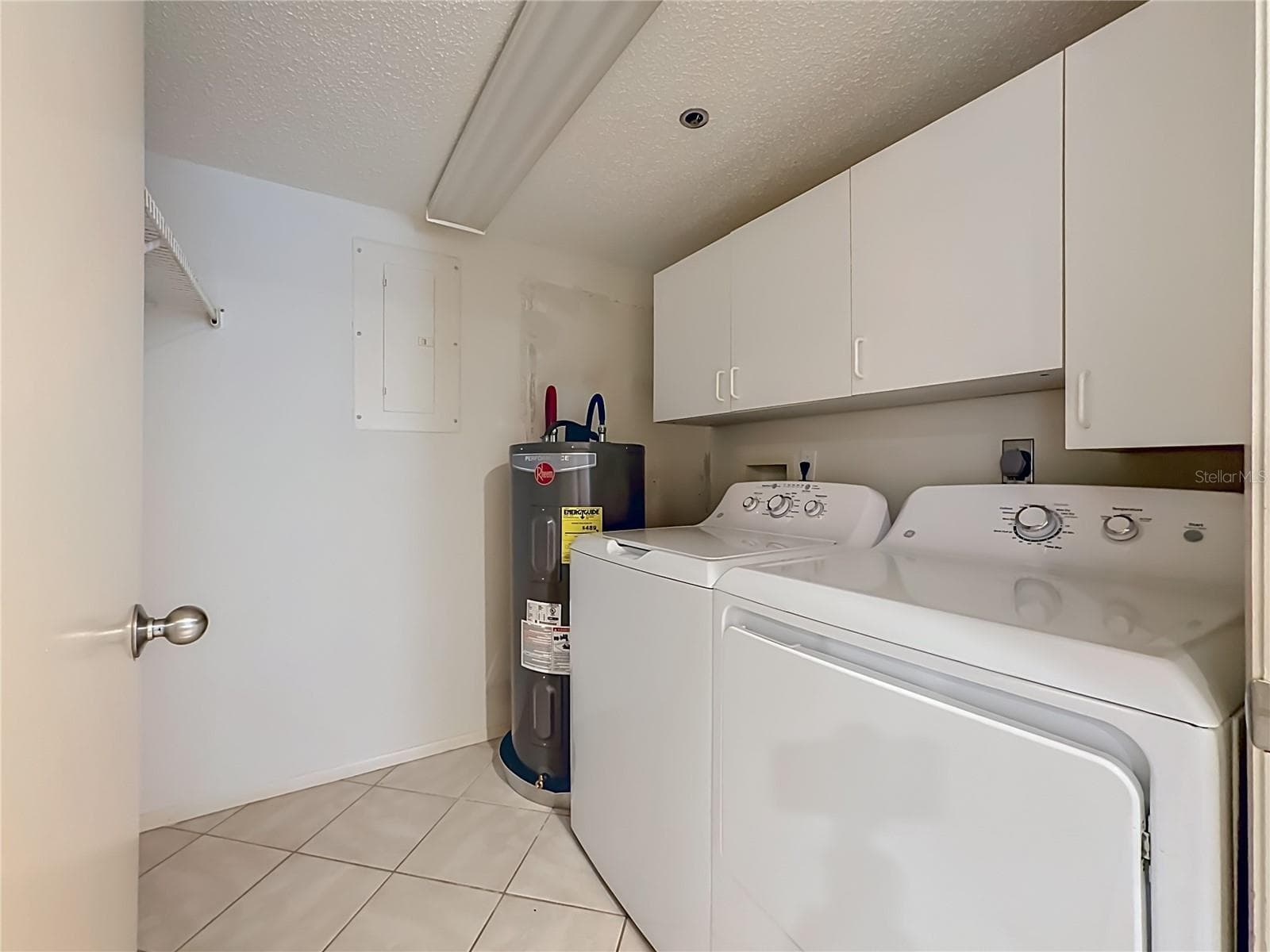Laundry room with full size washer and dryer and additional cabinets for storage. - 3740 PINEBROOK CIR #607, BRADENTON
