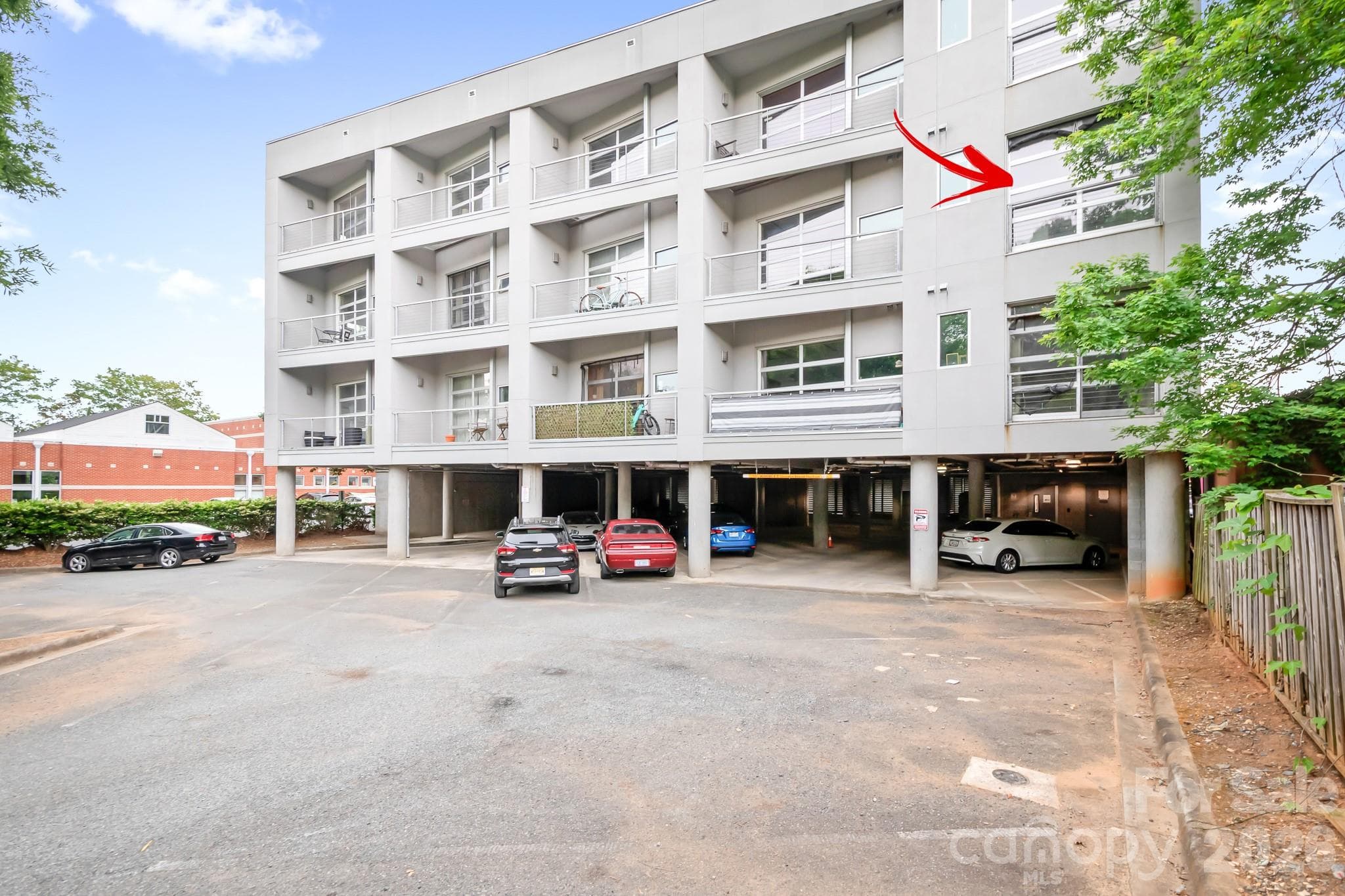 3rd Floor Unit on end with Garage Style Window/Door for open air loft feeling.  Positioned on the backside of the building for more quiet enjoyment. Overlooks parking area and homes. Super Cool Garage Door Window for Open Air Loft Feeling! FULLY FURNISHED! TURN KEY UNIT! - Charlotte