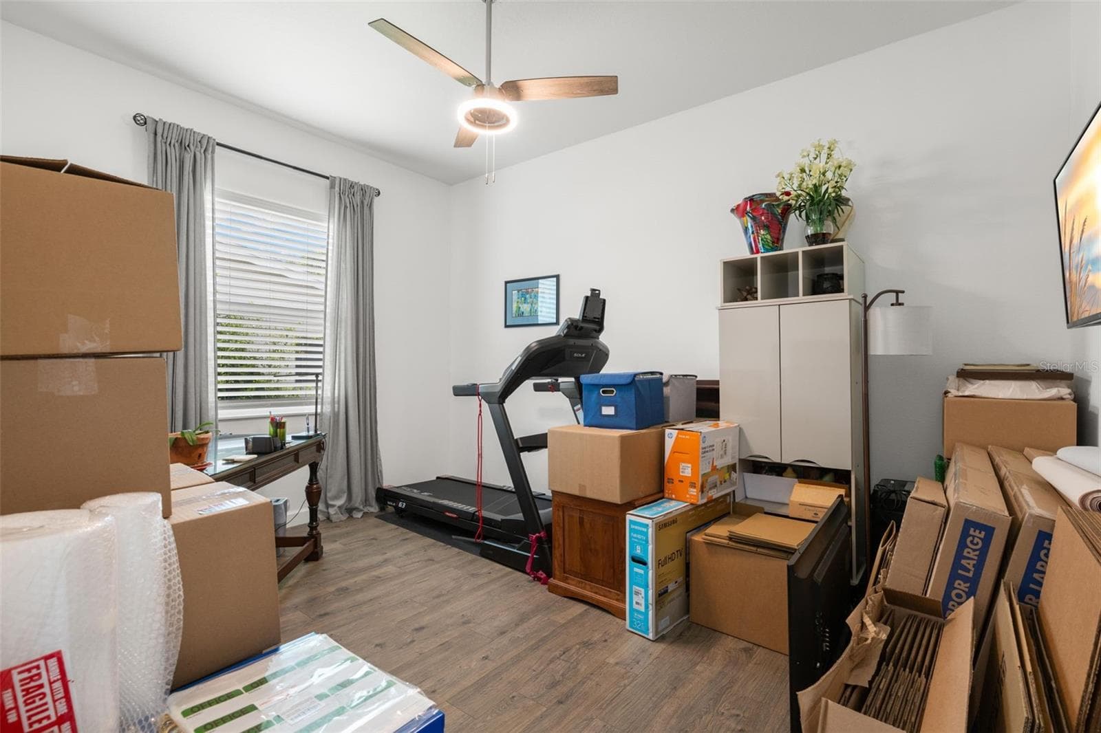 The flexible fourth bedroom or study includes wide-plank luxury vinyl flooring, a contemporary ceiling fan, abundant natural light, and a versatile layout adaptable for a home office, fitness room, or guest space. - 1720 VERDE DR, CLEARWATER