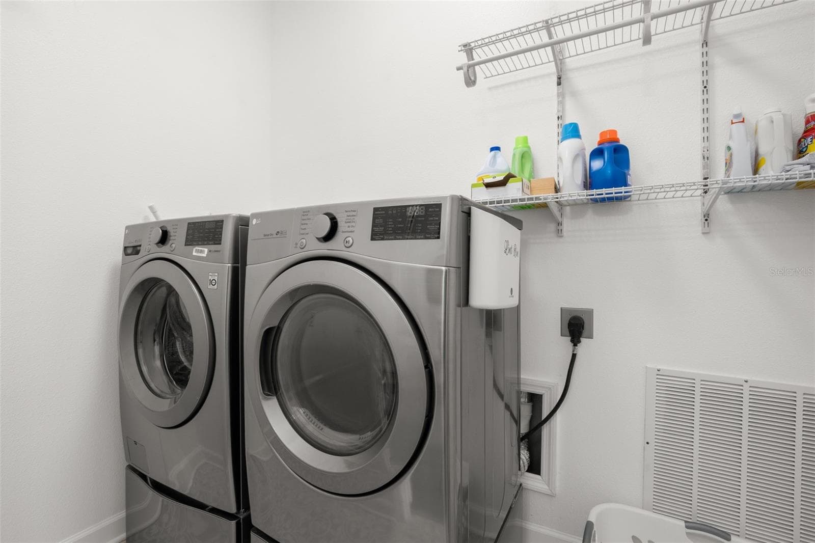 The interior laundry room includes built-in wire shelving for additional organization, side drying racks, and storage space. - 1720 VERDE DR, CLEARWATER