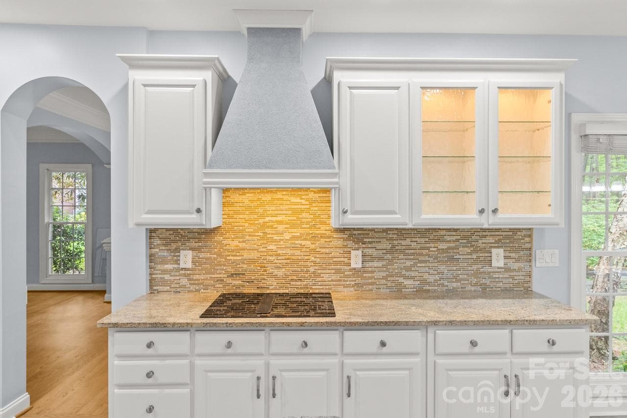 Imagine using the cooktop and displaying your favorite kitchen items in the glass fronted cabinet. - 4415 Everclear Court, Charlotte