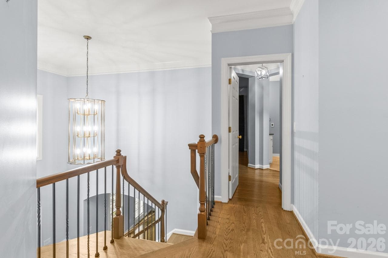 Upstairs landing provides a great view of the updated lighting in the foyer. - 4415 Everclear Court, Charlotte