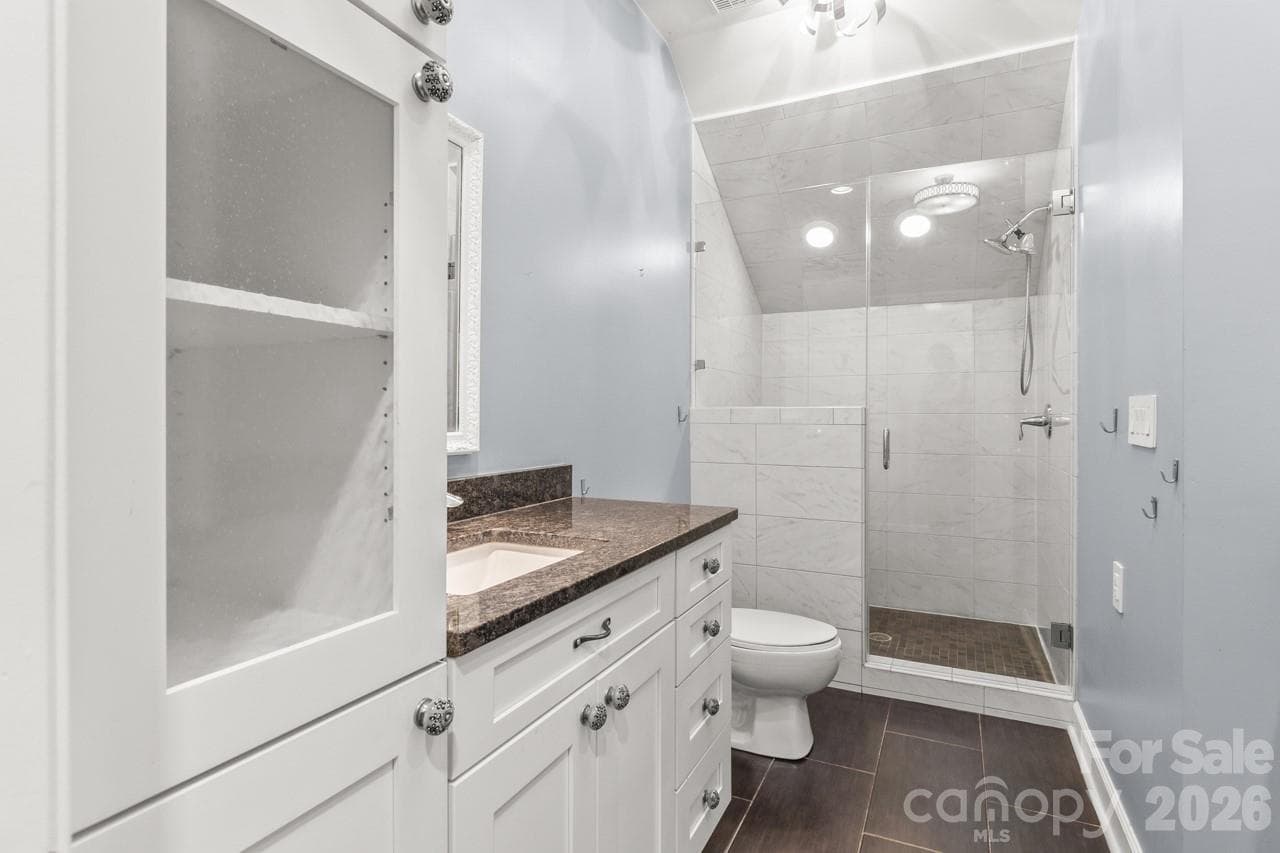 Upstairs hall bath boasts an updated shower and two vanities. - 4415 Everclear Court, Charlotte