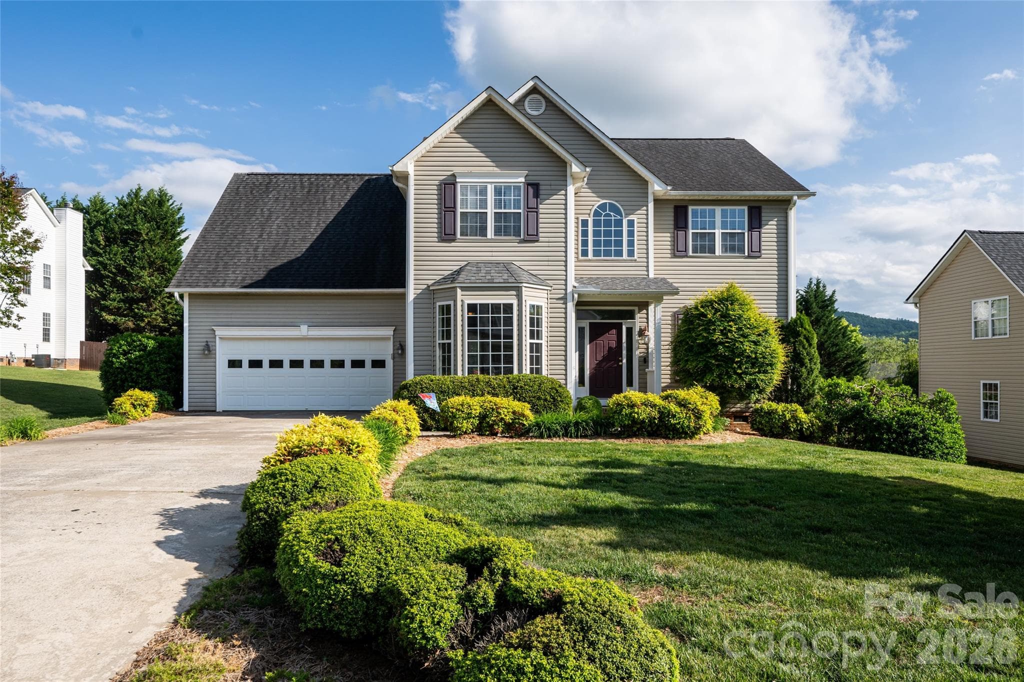 Front elevation of 48 Brownstone Court, Fletcher: traditional two-story built 2002, attached two-car garage, concrete driveway, architectural shingle roof, level cul-de-sac lot in Livingston Farms. - Fletcher