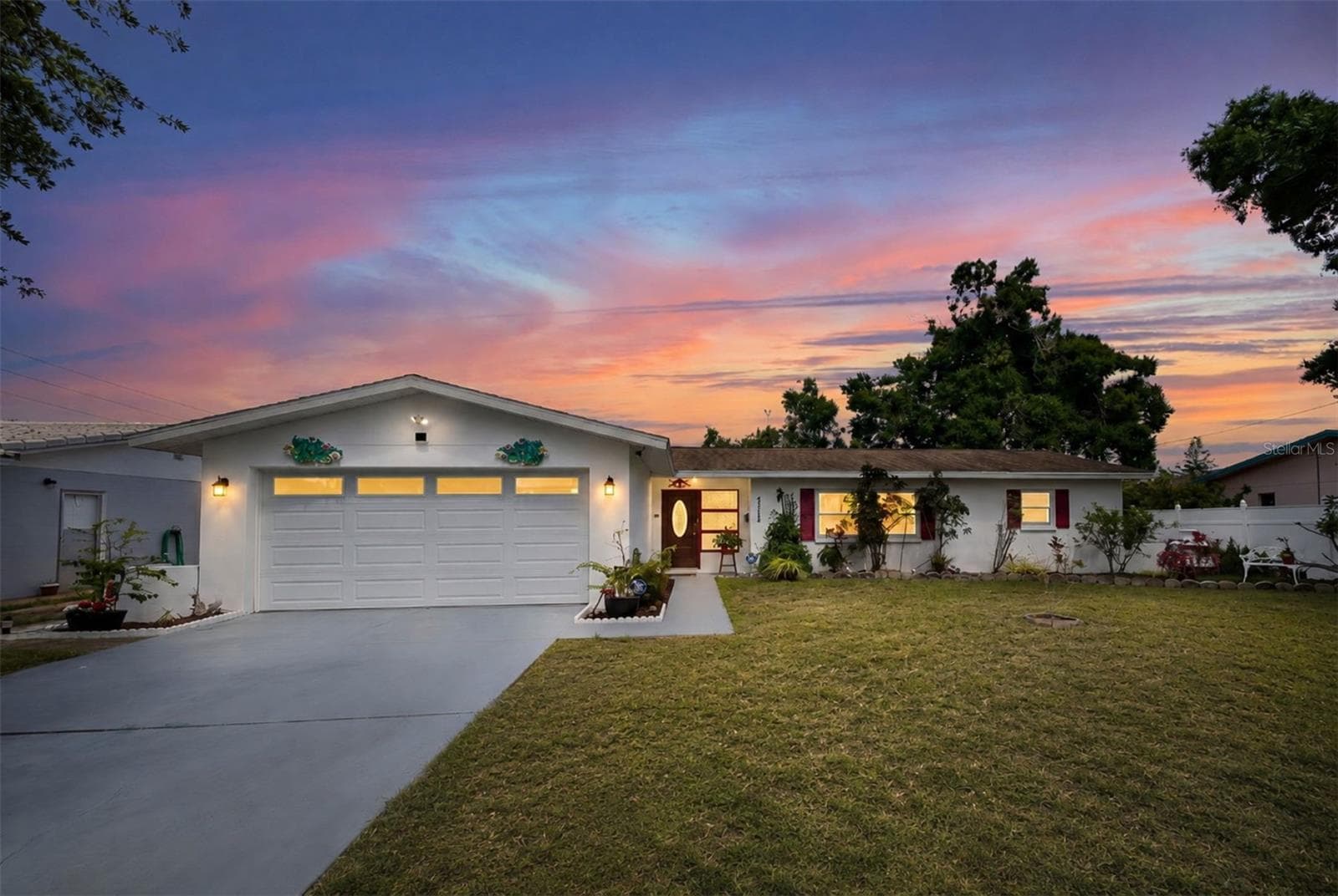 Coastal-inspired curb appeal with vibrant red accents and lush tropical landscaping - 6212 20TH ST S, ST PETERSBURG