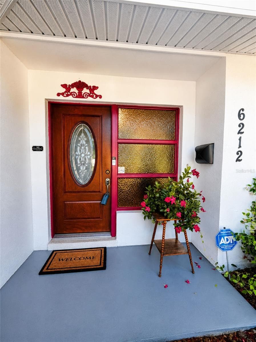 Rich wood entry door with decorative glass creates a warm first impression - 6212 20TH ST S, ST PETERSBURG