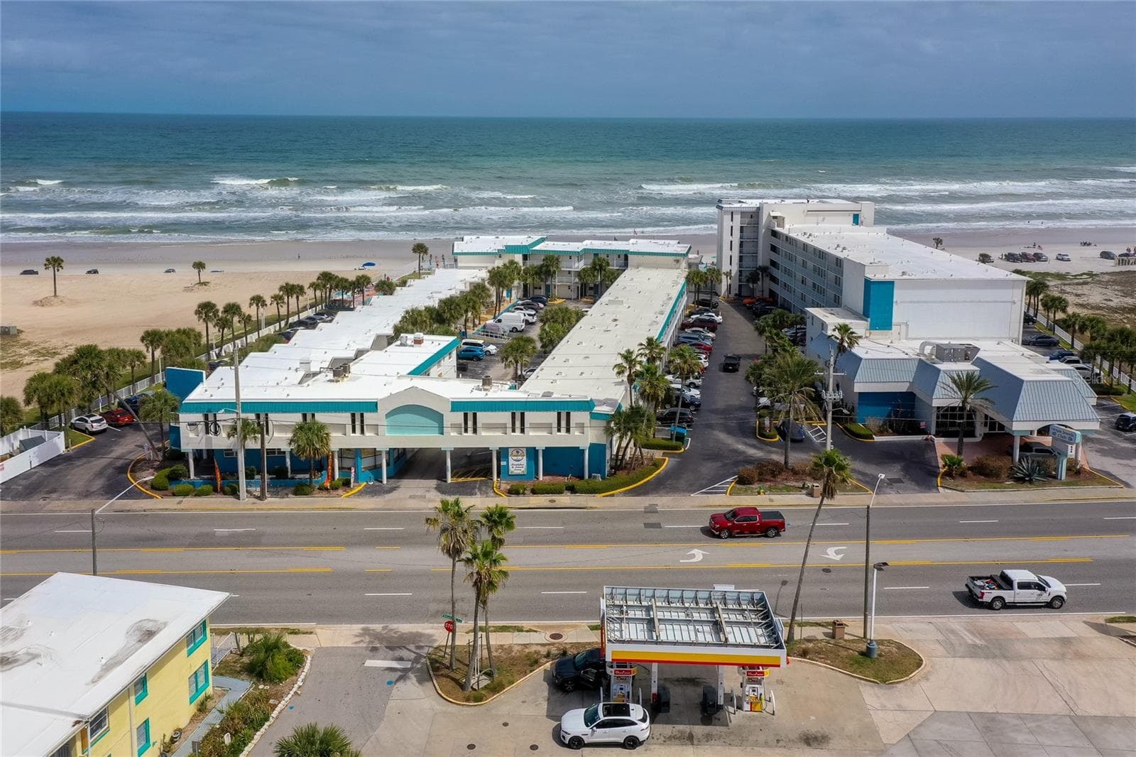 Oceanfront complex setting with direct beach access and a prime coastal location just steps from the sand. This elevated view highlights the community’s layout, parking, and proximity to the shoreline - 935 S ATLANTIC AVE #165, DAYTONA BEACH
