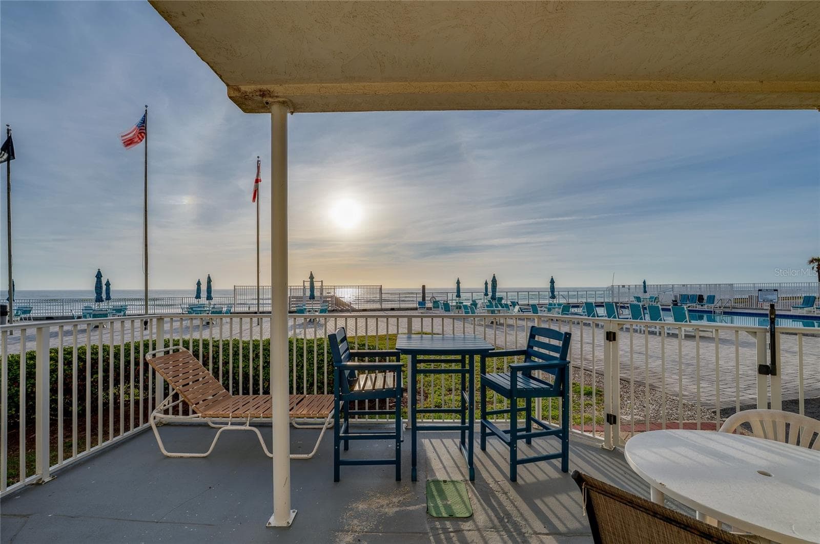 Private ground-floor patio offering stunning, unobstructed views of the Atlantic Ocean and the community pool. - 935 S ATLANTIC AVE #165, DAYTONA BEACH