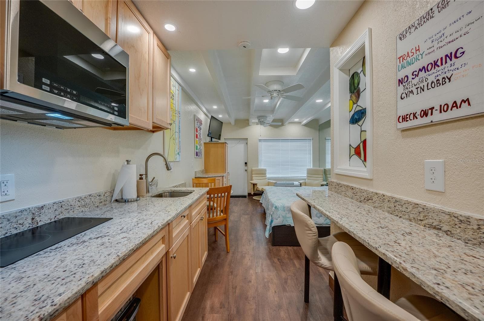A bright and airy view of the main living space, showcasing how the open layout maximize the studio’s footprint. The placement of the furniture allows for a clear sightline toward the outdoor patio. - 935 S ATLANTIC AVE #165, DAYTONA BEACH
