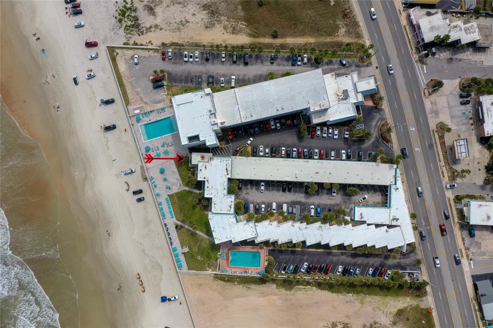 Northward-facing aerial view showing the property’s integration with the shoreline. - 935 S ATLANTIC AVE #165, DAYTONA BEACH