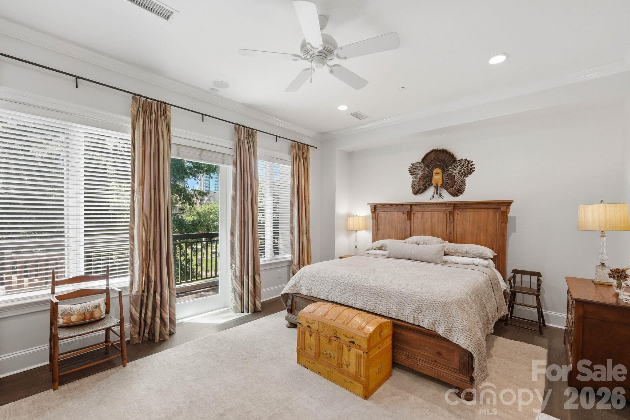 Spacious primary suite with private balcony access, oversized windows, hardwood flooring, and a serene retreat like atmosphere in the heart of Uptown Charlotte. - Charlotte