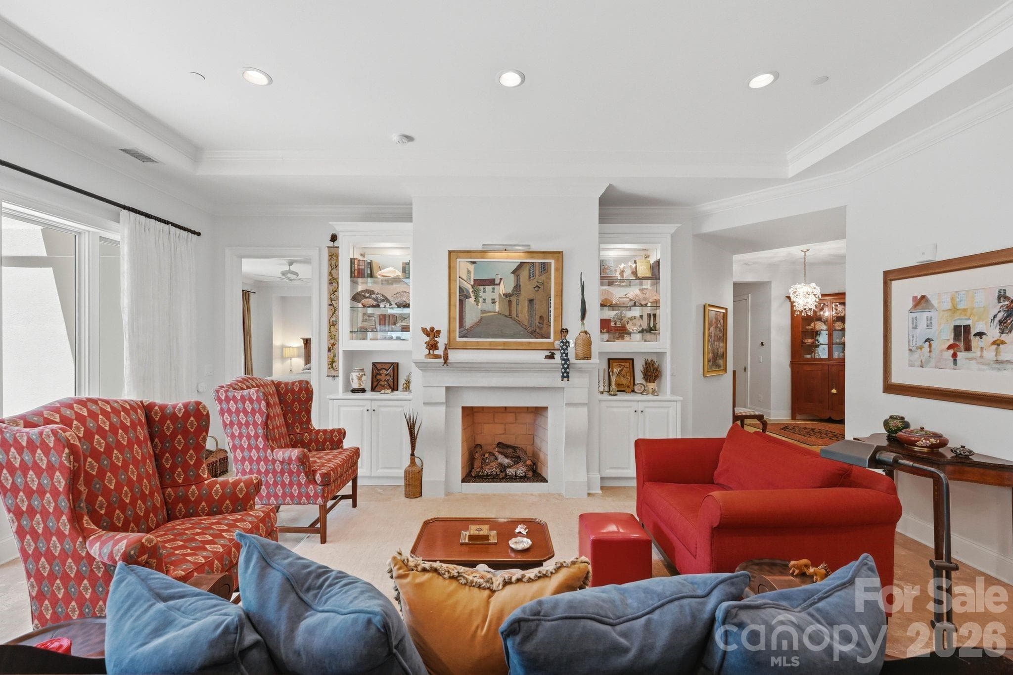 Sophisticated living room featuring custom built ins, a statement fireplace, soaring ceilings, and elegant gathering spaces designed for both entertaining and everyday comfort. - Charlotte