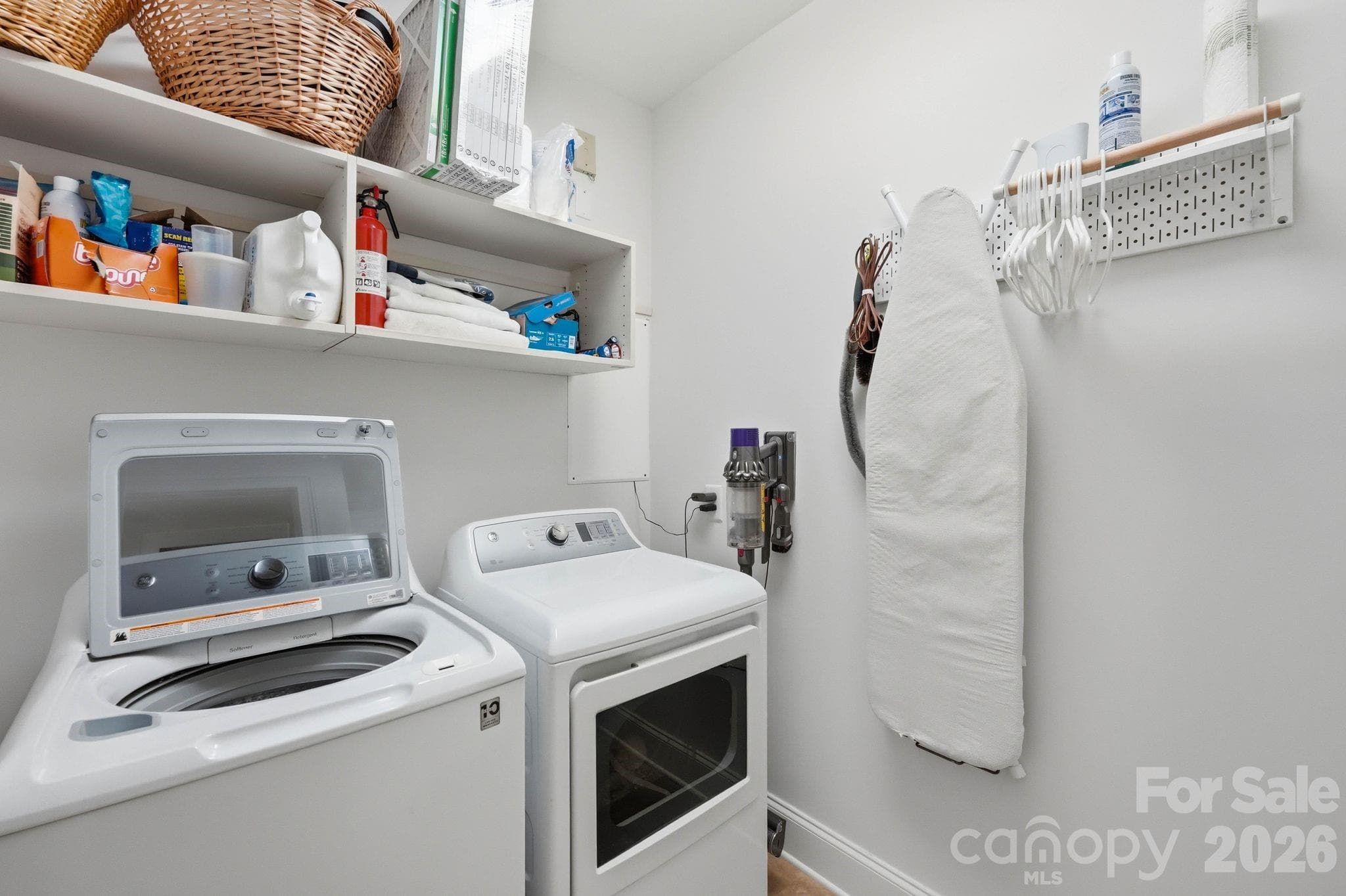 Functional laundry room with built in shelving, additional storage space, and thoughtful organization for convenient everyday living. - Charlotte