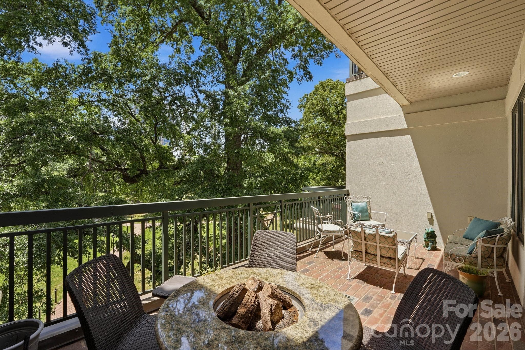 Private covered balcony overlooking Fourth Ward Park and Uptown greenery, creating a peaceful outdoor extension of the home. - Charlotte