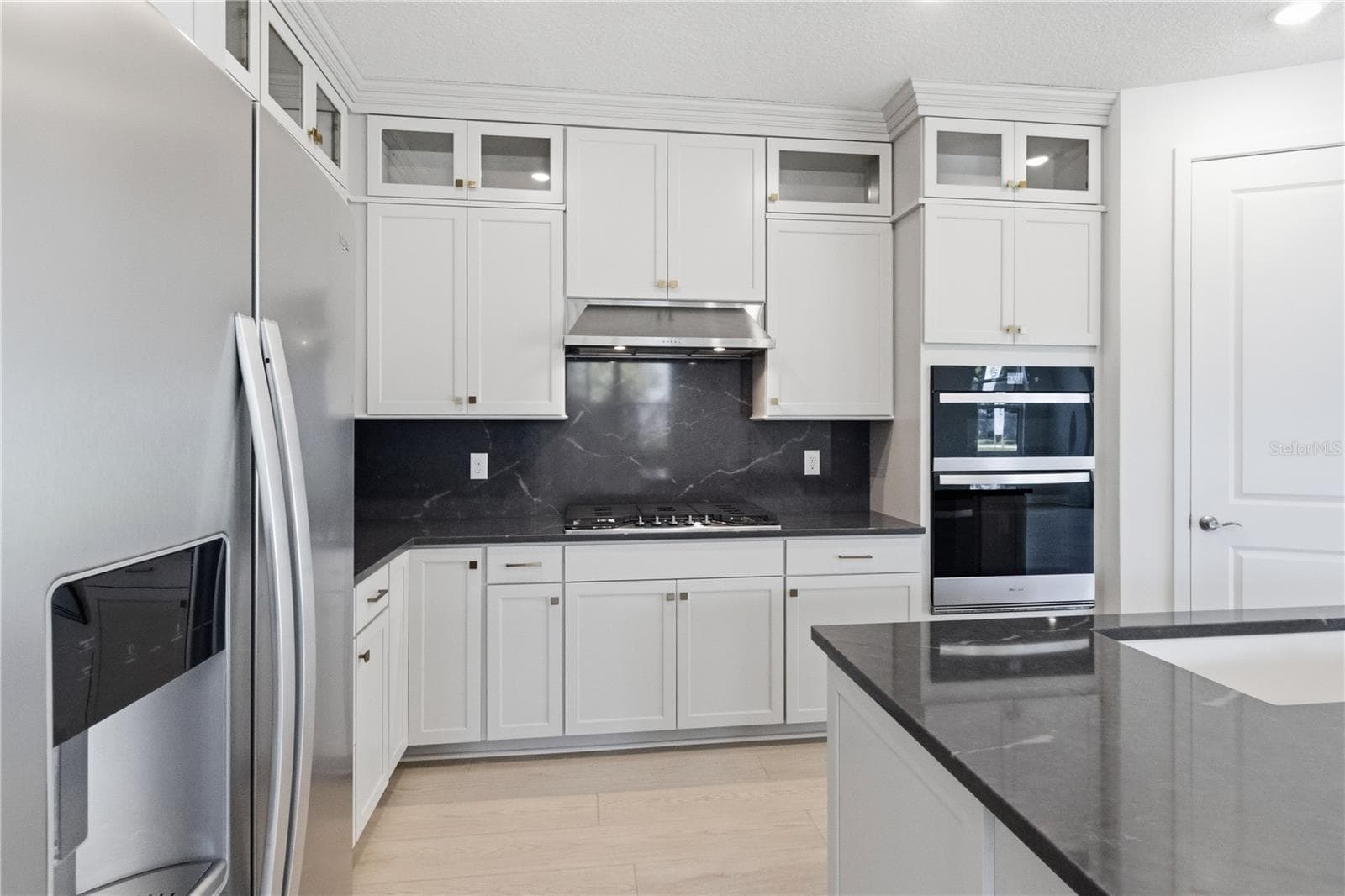 Modern kitchen with bright cabinetry, sleek counters, and a finished design center feel. - 13824 SUNLIGHT MEADOW DR, RIVERVIEW