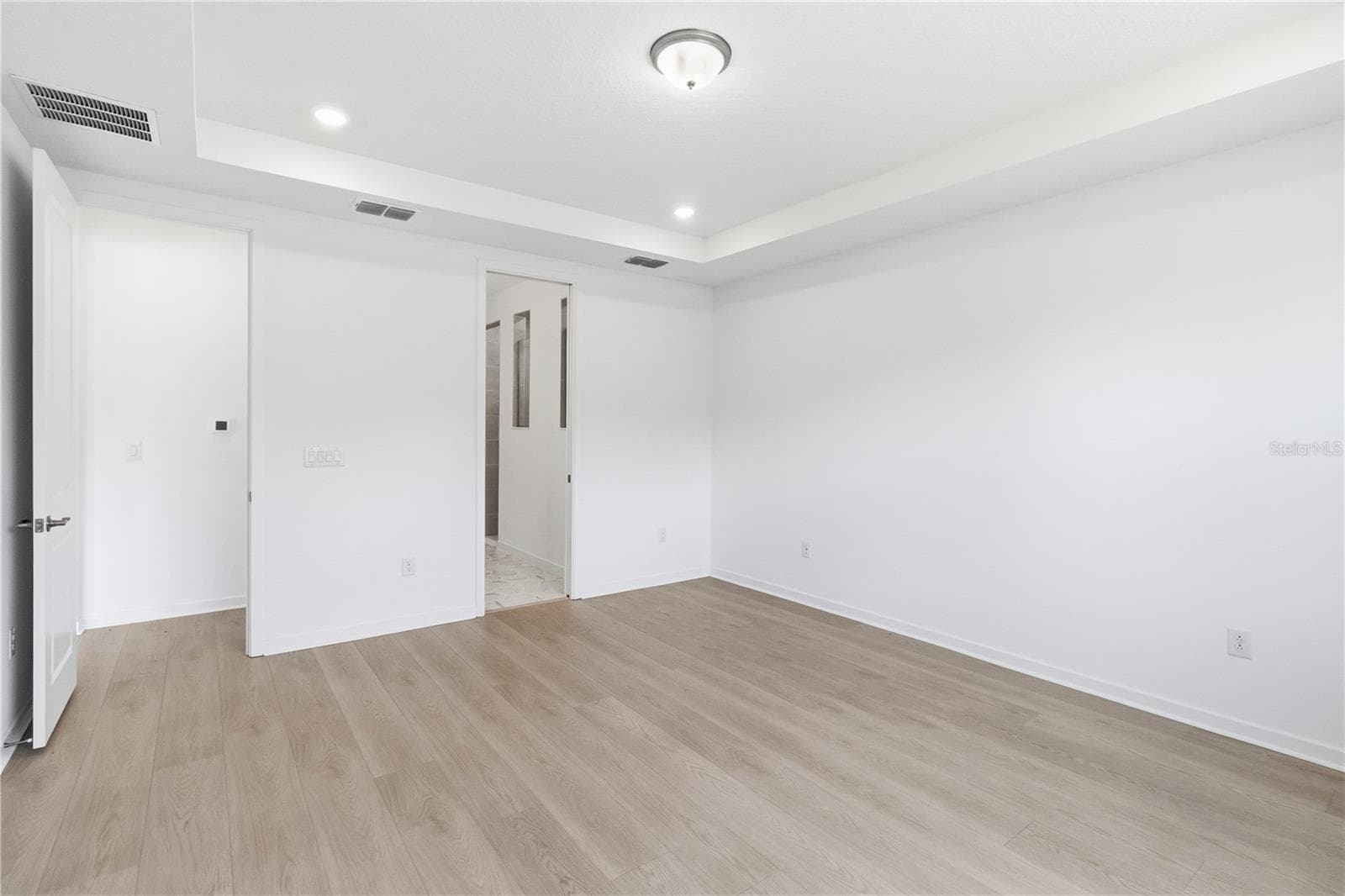 Spacious bedroom with warm flooring, bright walls, and flexible furniture options. - 13824 SUNLIGHT MEADOW DR, RIVERVIEW