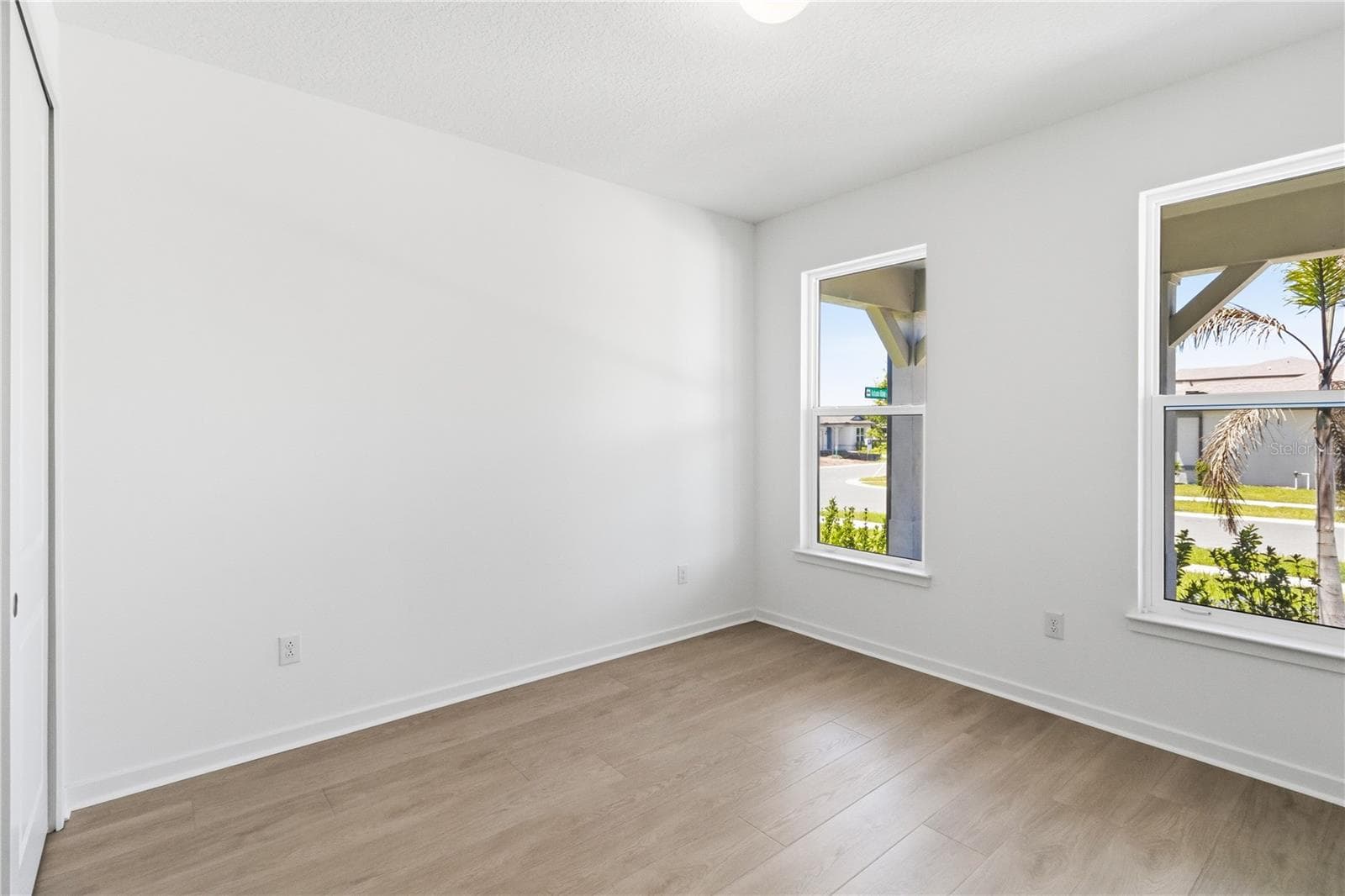 Bright flexible first floor bedroom with warm flooring and natural light for work, hobbies, or everyday use. - 13824 SUNLIGHT MEADOW DR, RIVERVIEW