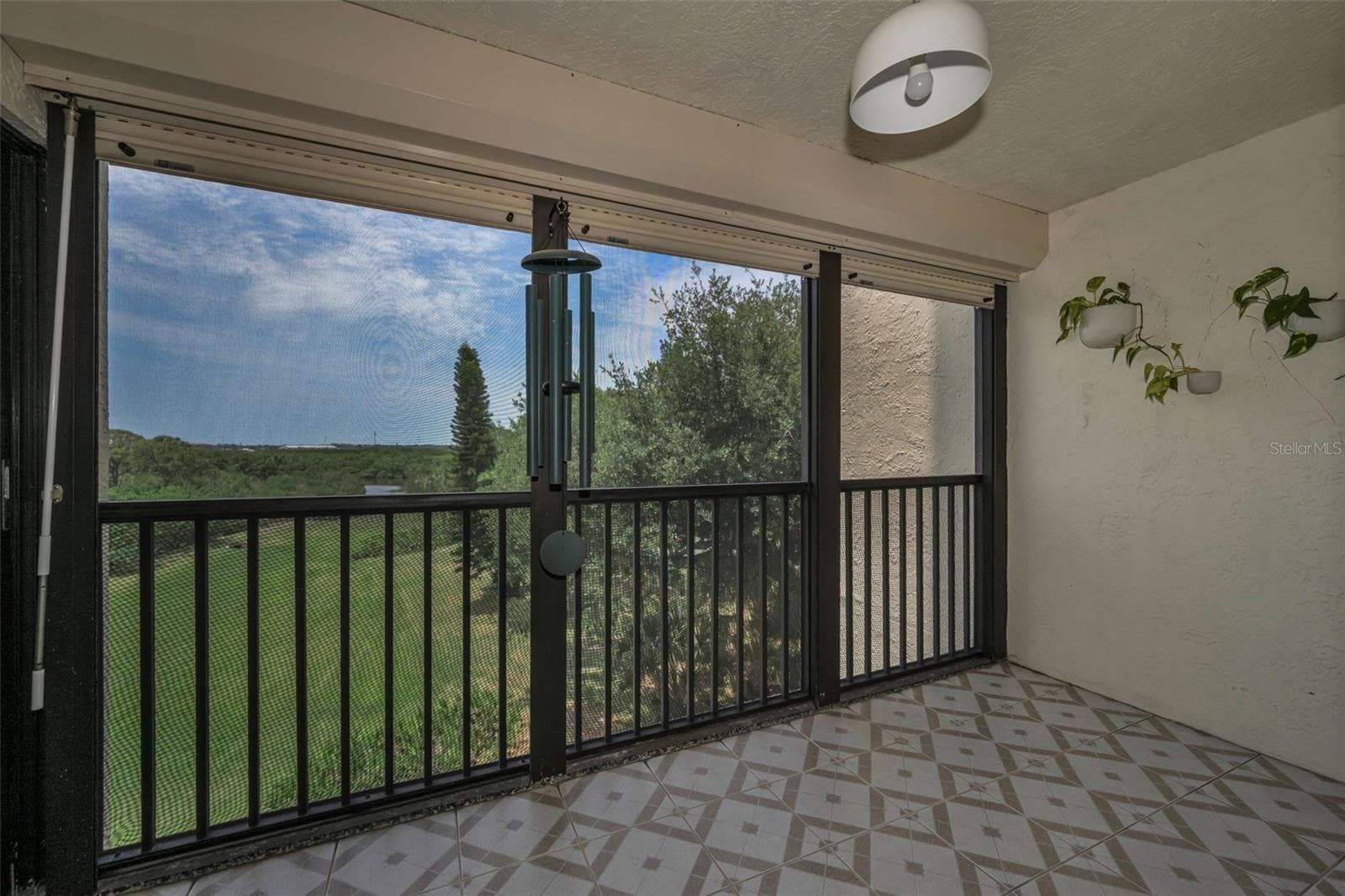 Rear, screened balcony overlooking plush landscaping and more. Beautifully tiled! - 5400 PARK ST N #303, ST PETERSBURG