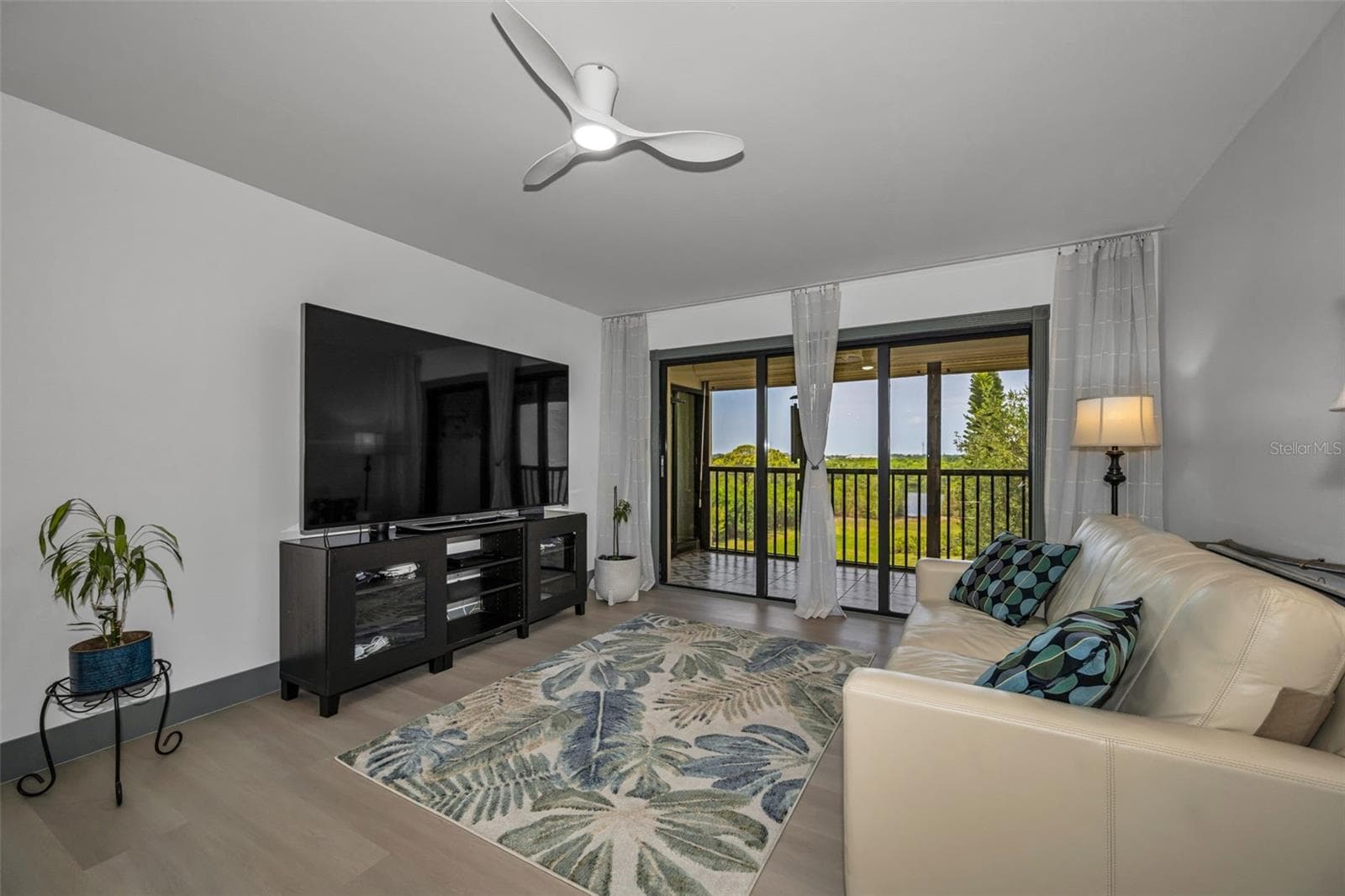 Living room with view out balcony and beyond!  All new vinyl plank flooring. - 5400 PARK ST N #303, ST PETERSBURG