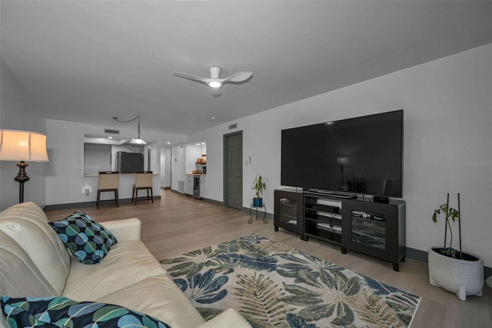 Another view of living room with new luxury vinyl plank flooring. - 5400 PARK ST N #303, ST PETERSBURG