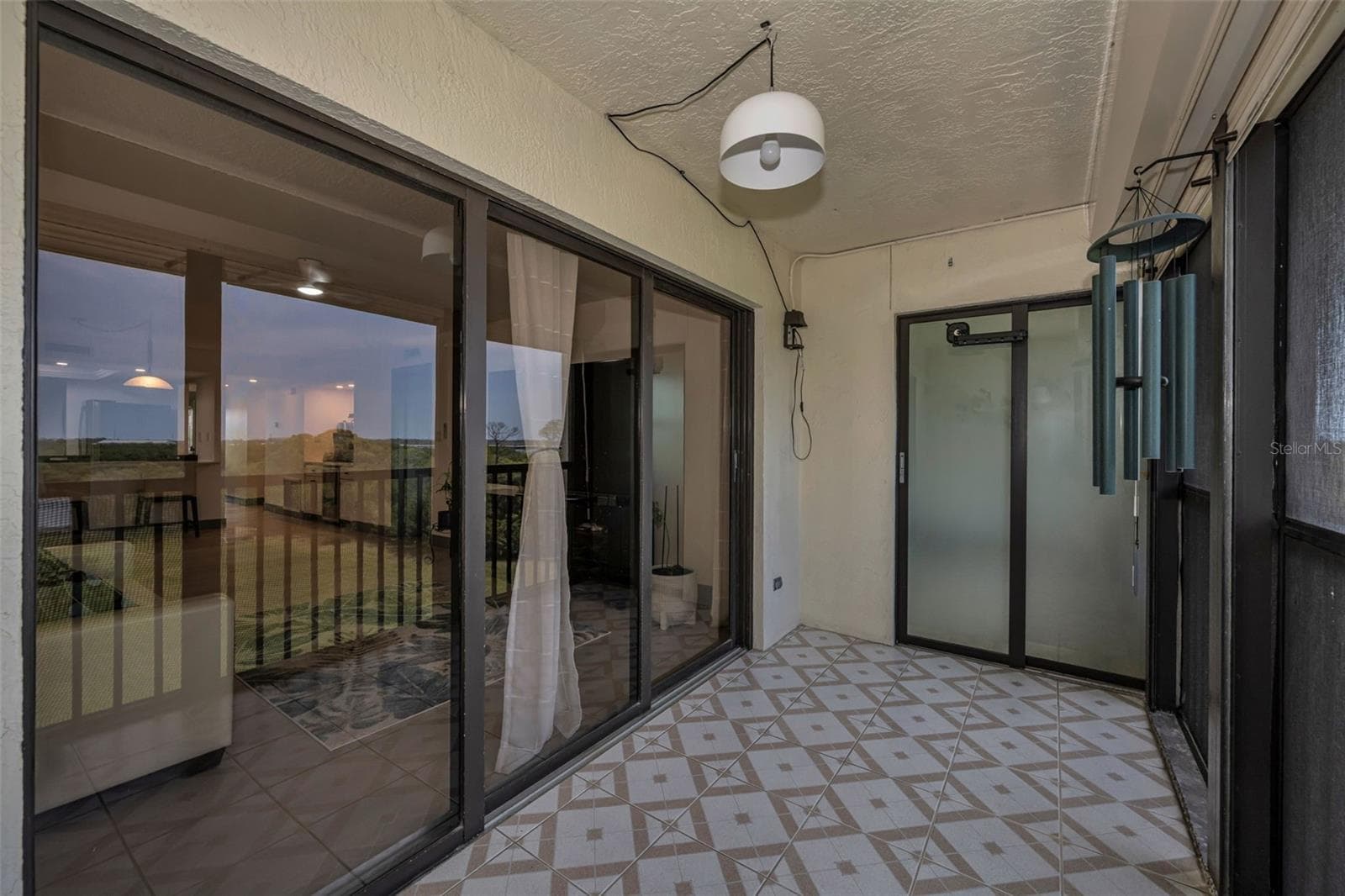 Balcony with sliding glass doors to living room and bedroom.  Screened in and shutters for protection. - 5400 PARK ST N #303, ST PETERSBURG