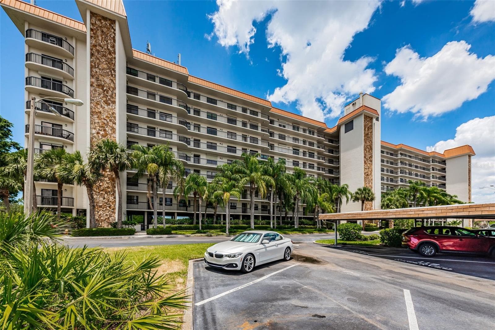 A very Tropical view of Otter Key!  Curved units and balconies on the ends of the building make this a stunning architectural feature; with under building parking and plush Palm Trees! - 5400 PARK ST N #303, ST PETERSBURG