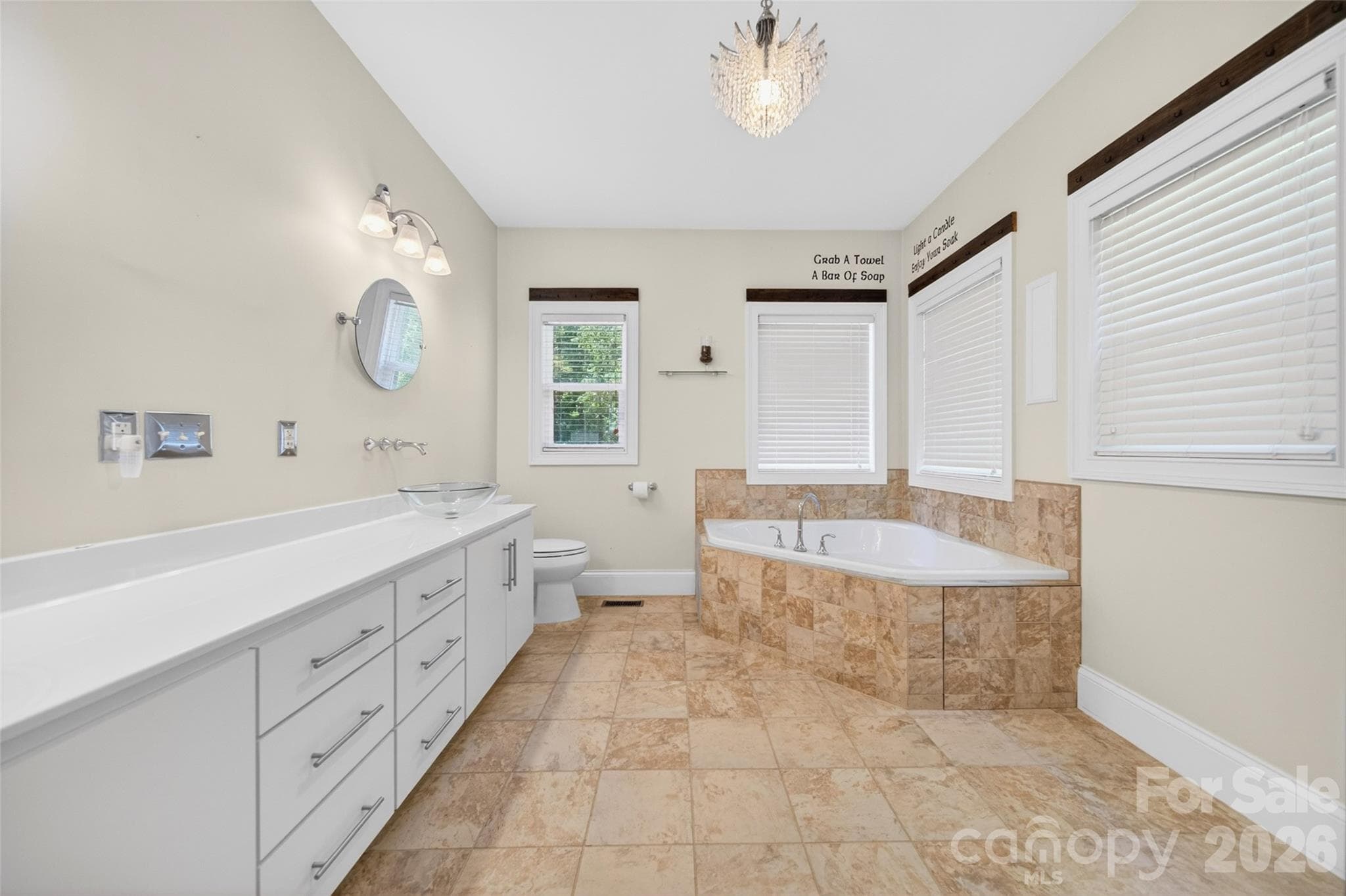 Primary En Suite bath features large corner soaking tub and a corner walk-in shower, dual vanity with vessel sinks and abundant storage. - 2977 Cabin Creek Drive, Catawba