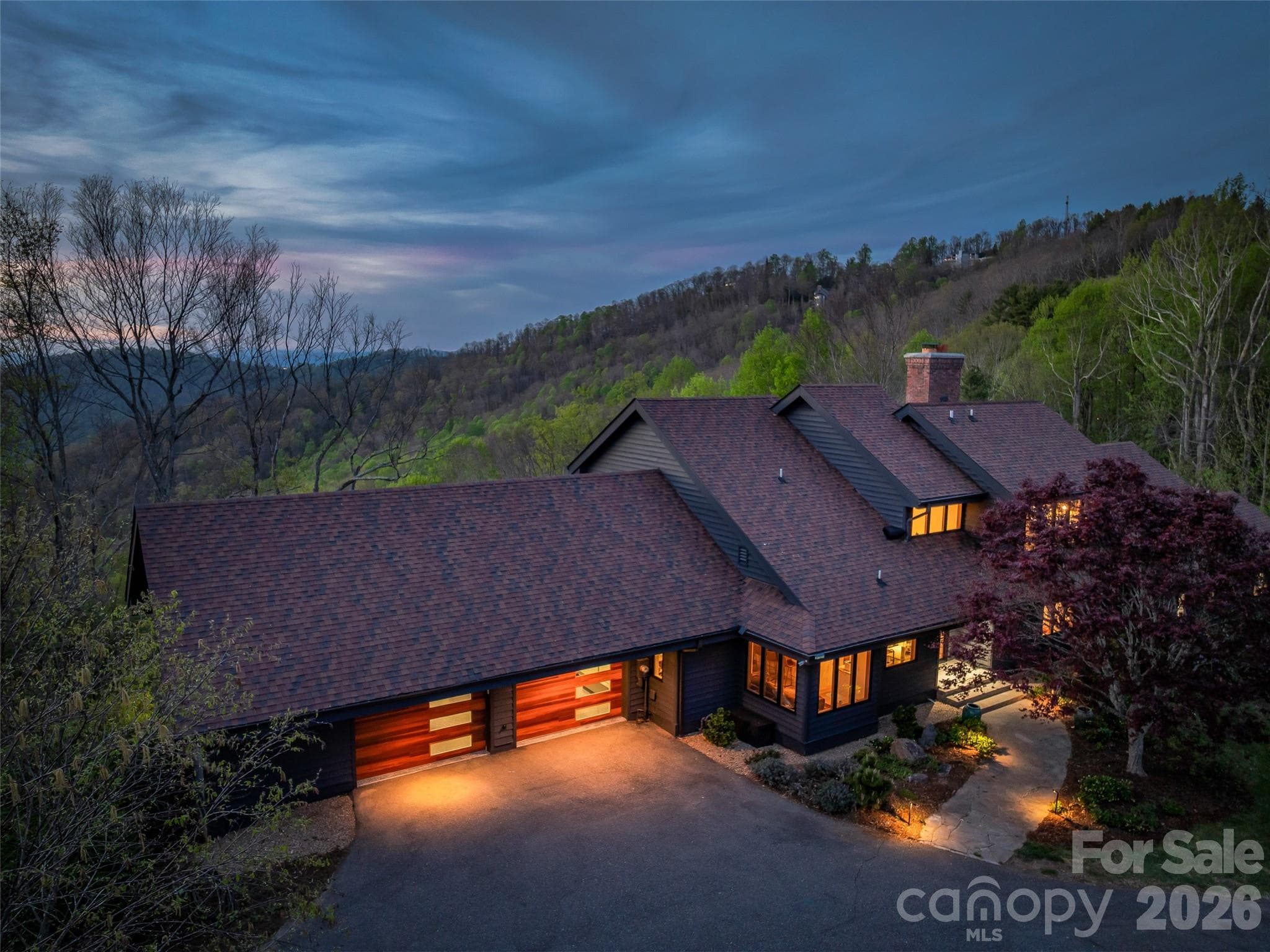 Estate driveway leads to oversized two car garage with EV charging. Newly installed insulated steel garage doors feature stylish Midcentury modern wood appearance facades. - 100 Big Spring Drive, Asheville