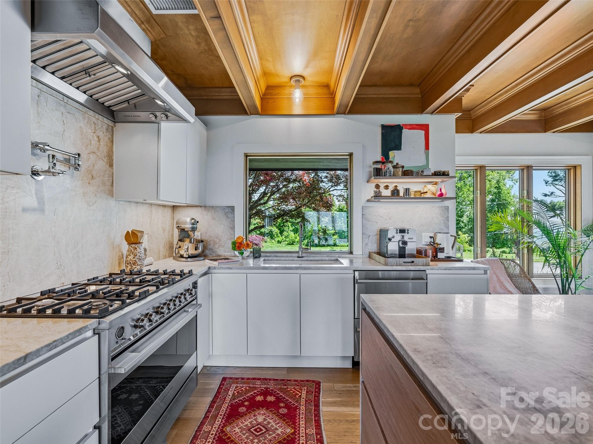 The kitchen includes stainless steel Fisher and Paykel appliances, and custom Hattian pull-out cabinetry and drawers with under cabinet lighting. - 100 Big Spring Drive, Asheville
